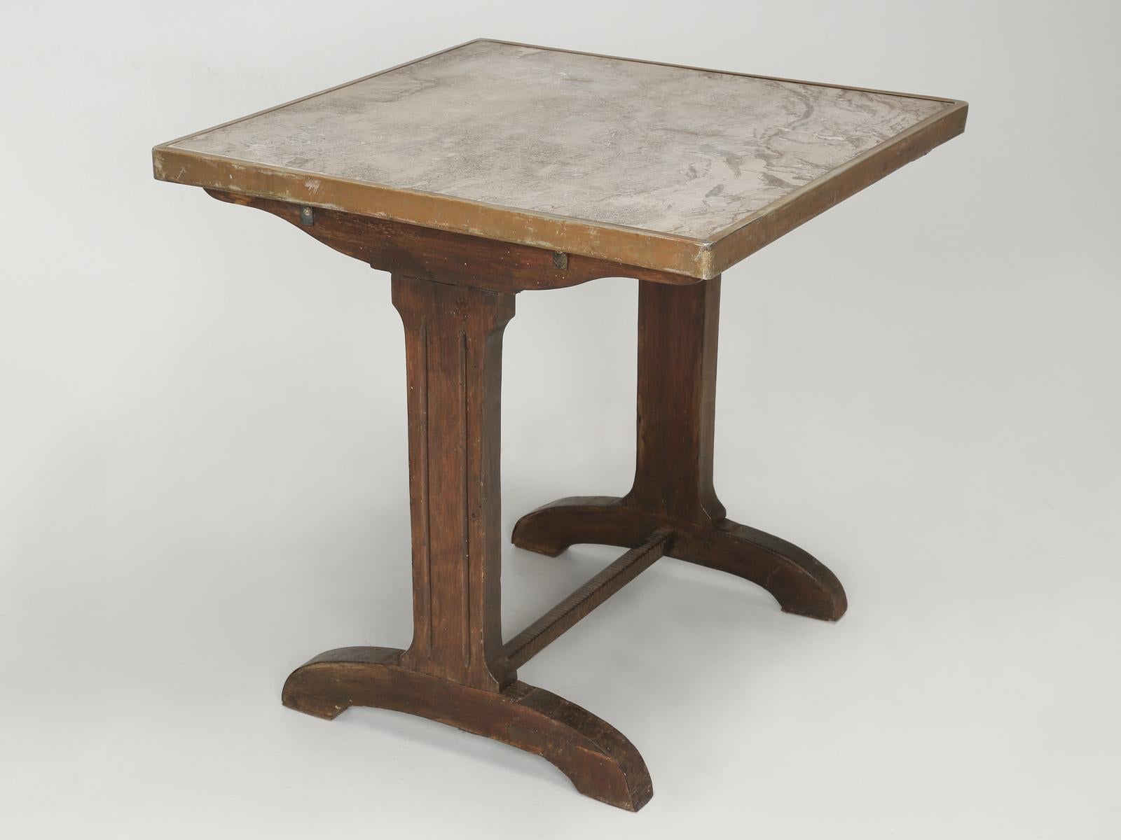 Antique French Bistro table in a very unusual square shape. Judging by the wear on the marble top, our best guess is that this was made in the early 1900’s. Please note all the surface scratches on the marble bistro table top and old repairs at the