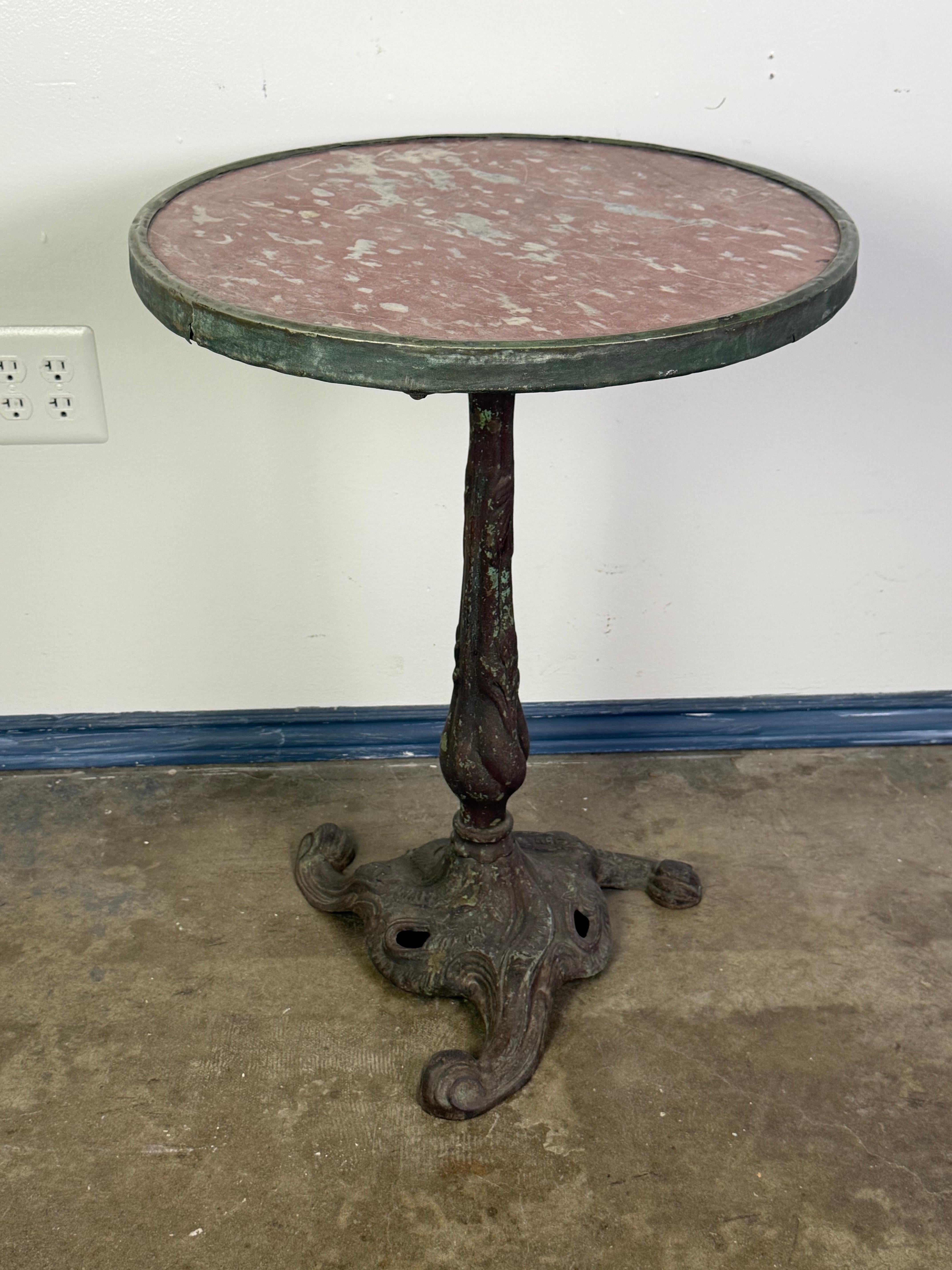 Esta encantadora mesa de bistró francesa del siglo XIX encarna la elegancia rústica de la cultura de los cafés europeos. La encimera circular es de mármol Rosso Verona ricamente abigarrado, con suaves vetas blancas sobre un fondo rojo terracota