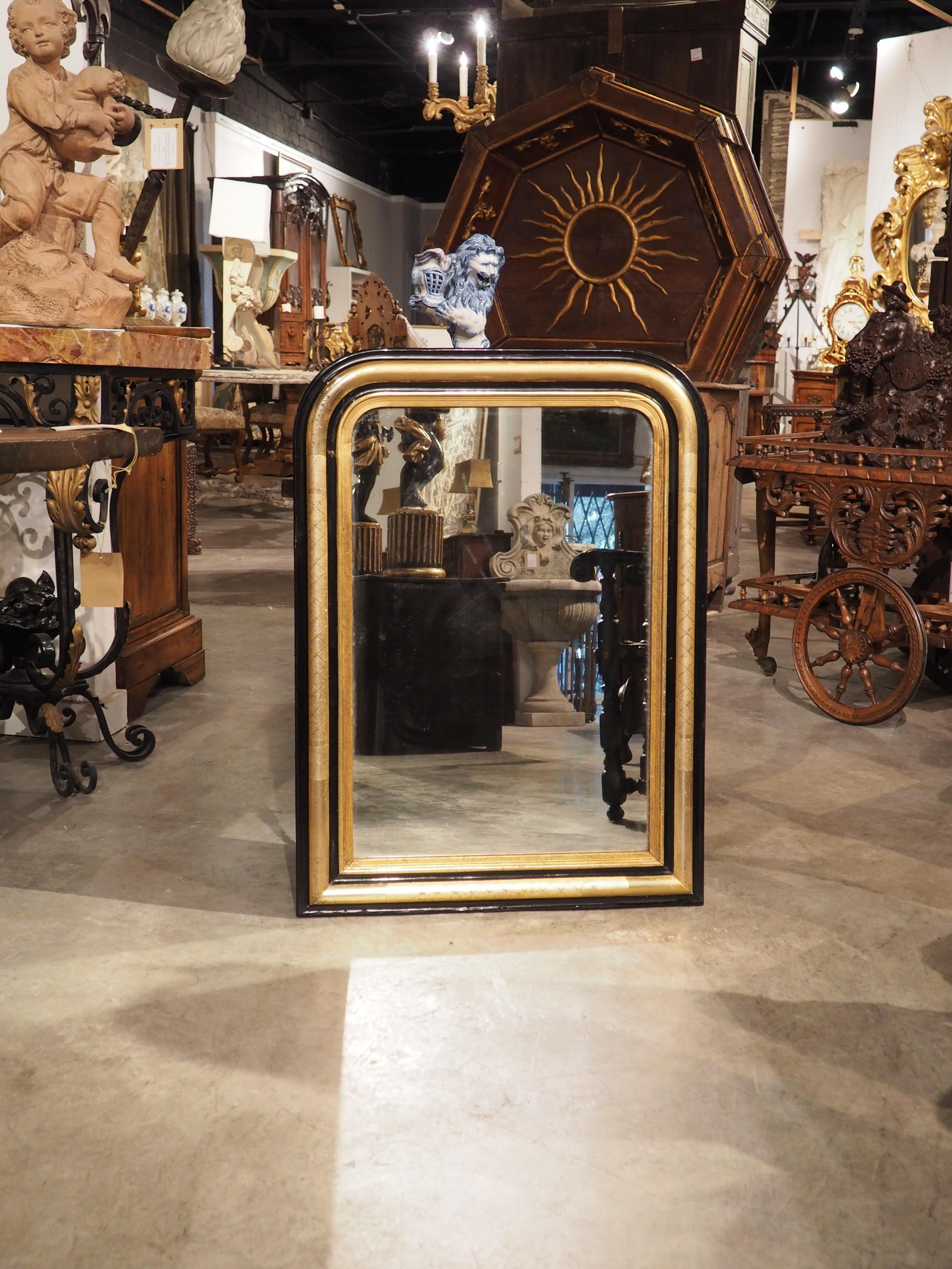 Add a touch of restrained elegance to your home with our black and giltwood Louis Philippe-style mirror. Hand-crafted in France, circa 1850, this mirror features hand-painted black cavetto cornices that offer a stark contrast to the giltwood quarter