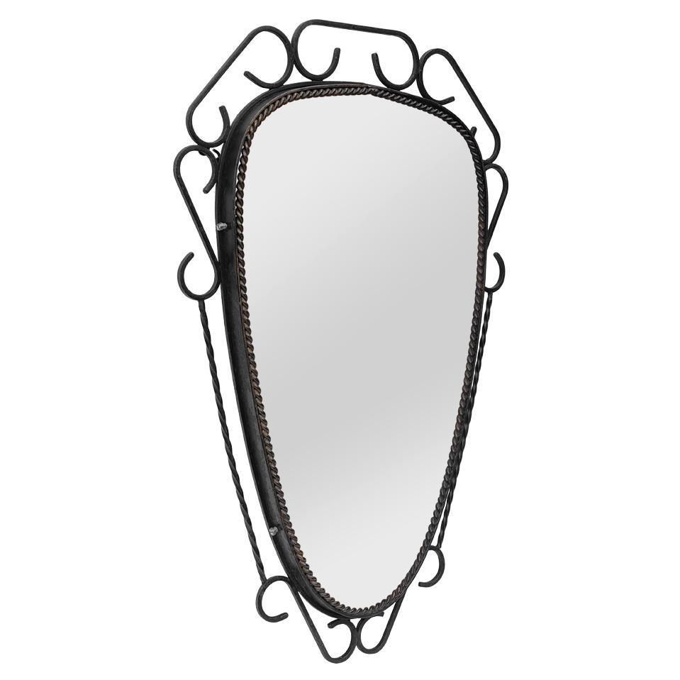 Antique French wrought-iron mirror in black color patinated dating from the 60s. Antique wrought-iron frame decorated with scrolls and twists. Frame width: 8 cm / 3.14 in. Modern glass mirror. Wood back.