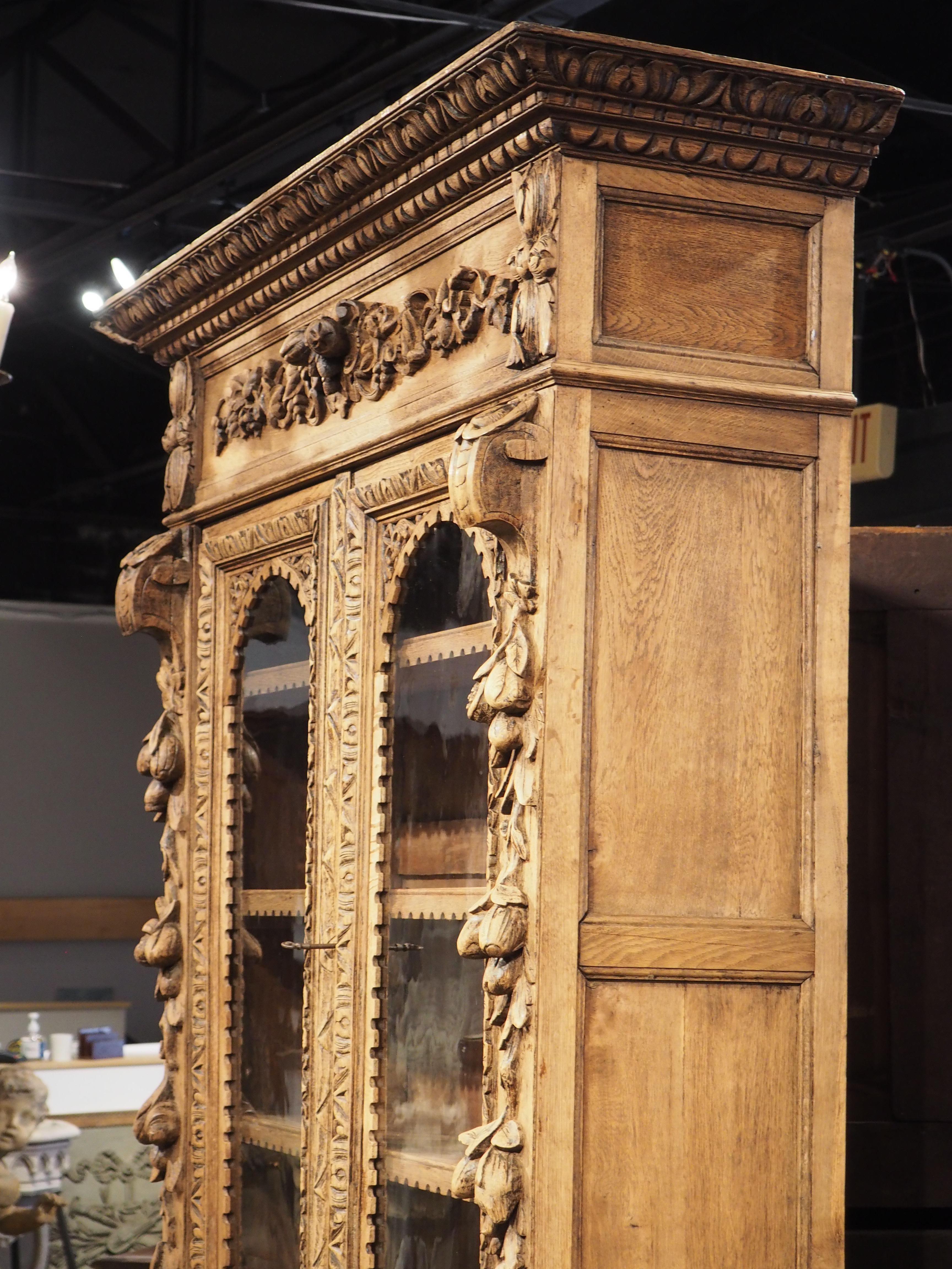 Featuring two hunt trophies and detailed motifs inspired by nature, this oak buffet deux corps was hand-carved in France, circa 1870. Traces of the original finish are still visible, but the wood was previously bleached, giving it a warm, golden