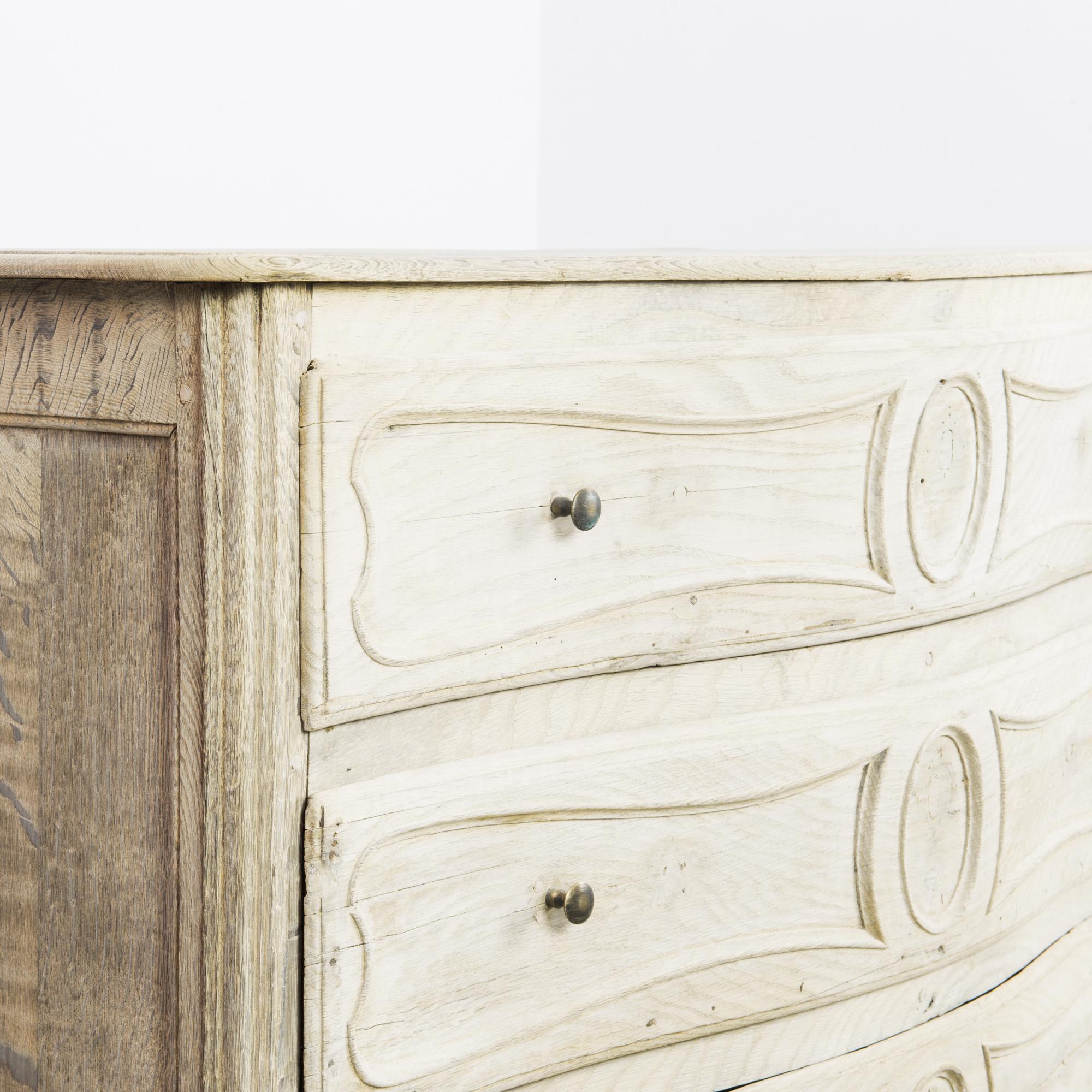 This bleached oak buffet with three drawers and lower shelves was made in France. The symmetrical features give it an understated elegance, complemented by the graceful curves of the scalloped apron and cabriole legs. Reeded sections on the front