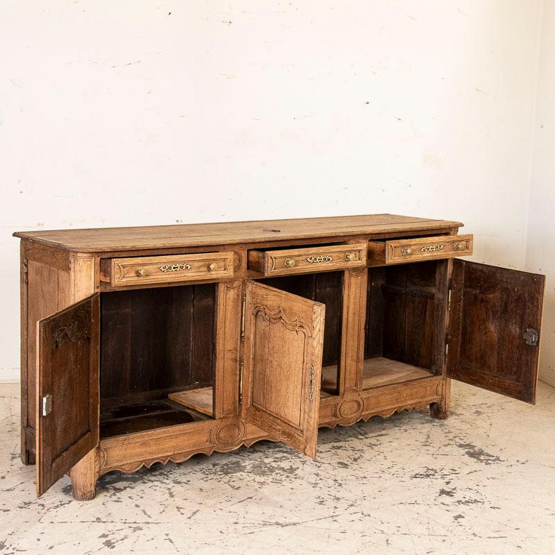 This long sideboard shows off its French style in the carved panels and lovely details along the skirt and drawers. The bleached finish gives it a fresh and welcoming look for today's modern home. Typical separation of planks, signs of cracks, etc.