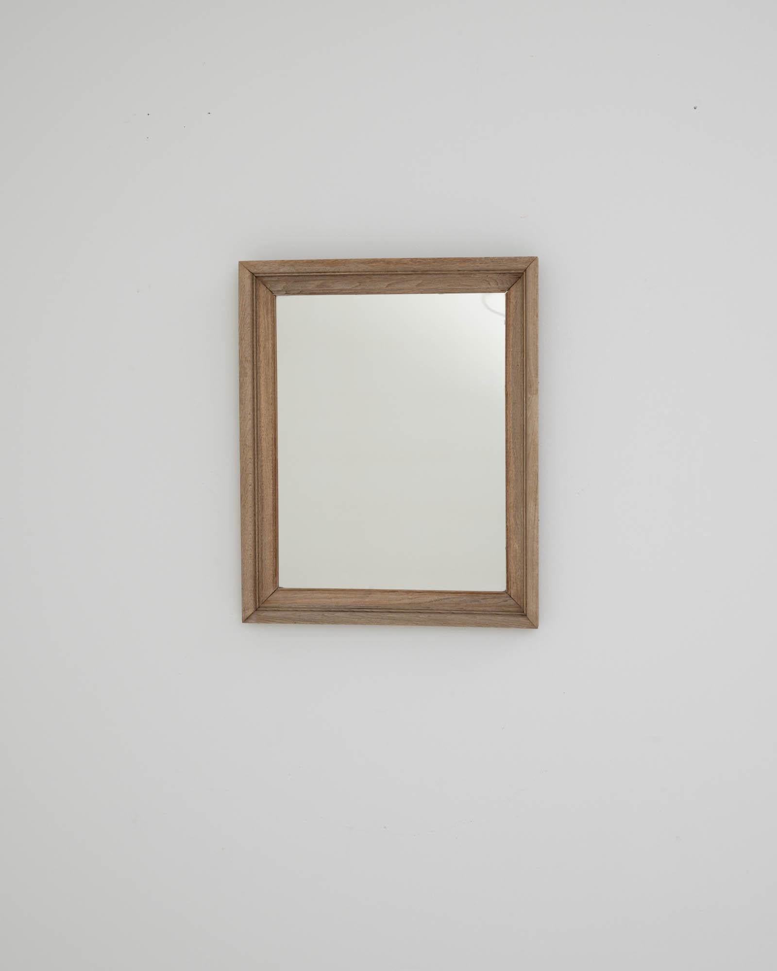 Miroir en bois fabriqué dans la France des années 1900. La forme rectangulaire simple et moulée de ce miroir dégage une impression de calme ensoleillé. Ce miroir unique en son genre associe un design traditionnel à une sensibilité minimale, ce qui