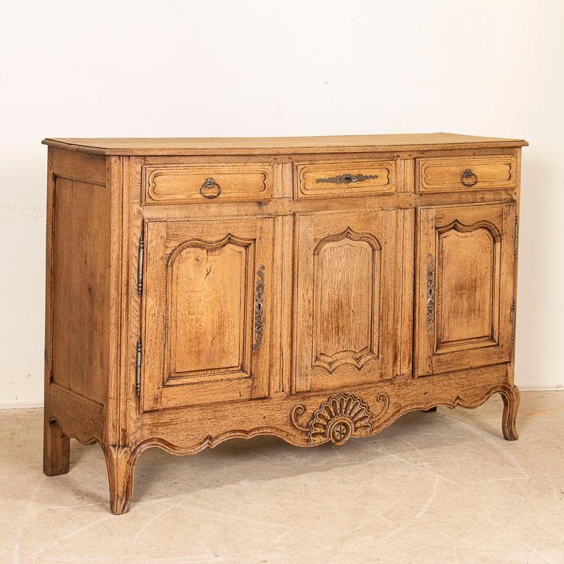 This 5.5' long sideboard shows off its French style in the carved panels and lovely details along the skirt, door & drawer panels. The bleached finish gives it a fresh and welcoming look for today's modern home and it sits gracefully upon cabriolet