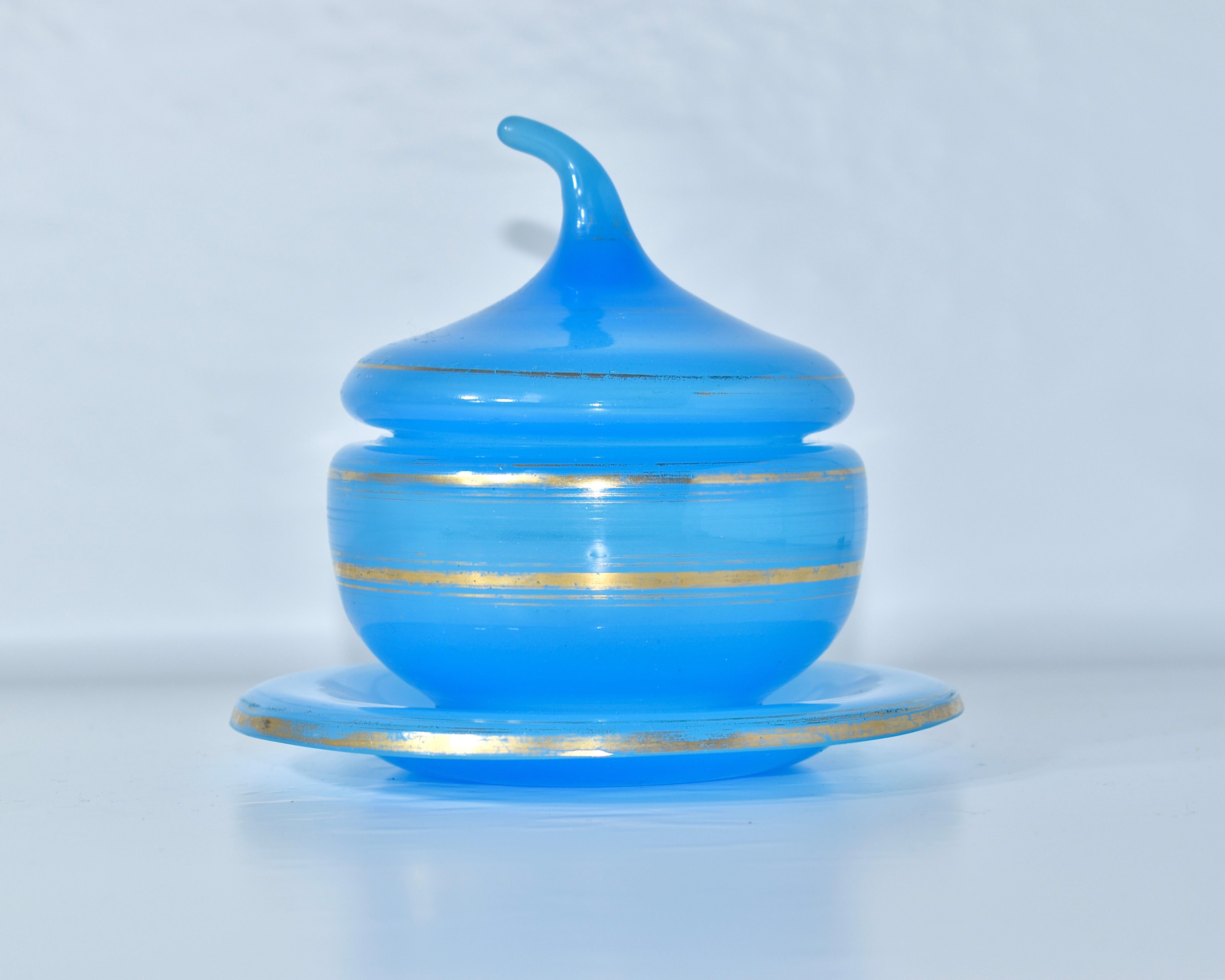 Belle bonbonnière, sucrier avec assiette et couvercle, verre opalin

Verre opalin bleu avec rehauts de dorure

France, Fin du XIXe siècle.