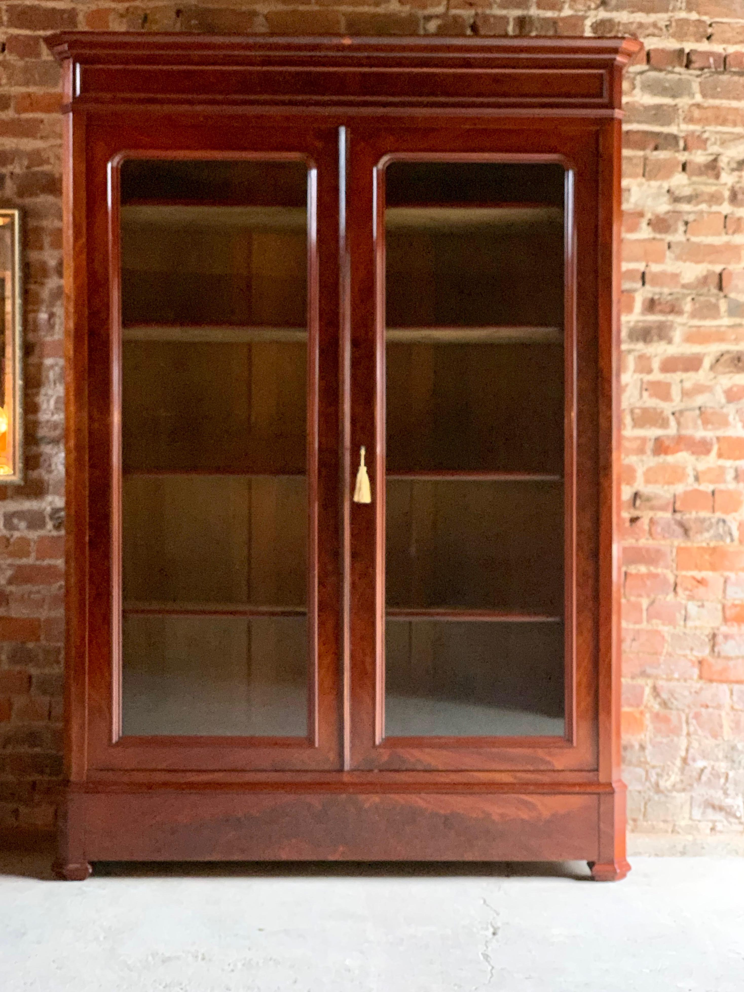 Antique 19th century French flamed mahogany bookcase vitrine, circa 1875.

A fabulous 19th century French flamed mahogany two door bookcase Vitrine, circa 1875, the large overhanging cornice above two glazed doors with four adjustable shelves within