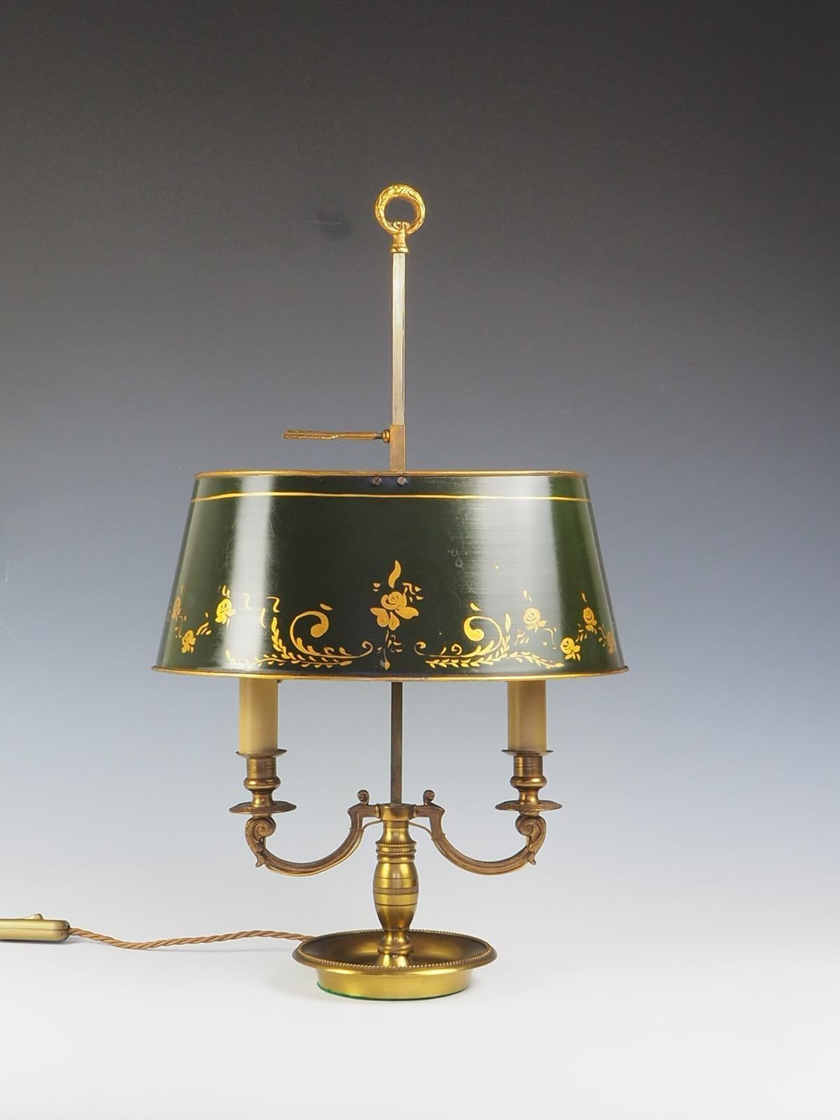 Die antike französische Bouillotte-Tischlampe aus dem 20. Jahrhundert ist ein wunderschönes Stück aus Messing mit zwei Armen und einem verstellbaren grünen Schirm.

Die Lampe strahlt Eleganz und Raffinesse aus und ist damit die perfekte Ergänzung