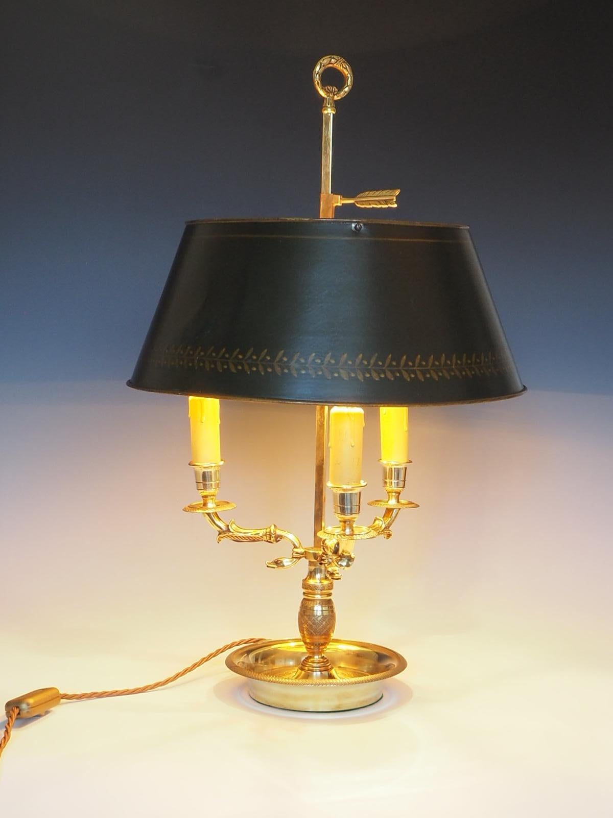 Antique French Bouillotte Table Lamp from the 19th Century is a stunning piece crafted from brass, featuring a serpent scrolled three armed base and an adjustable green shade.

The lamp exudes elegance and sophistication, making it a perfect
