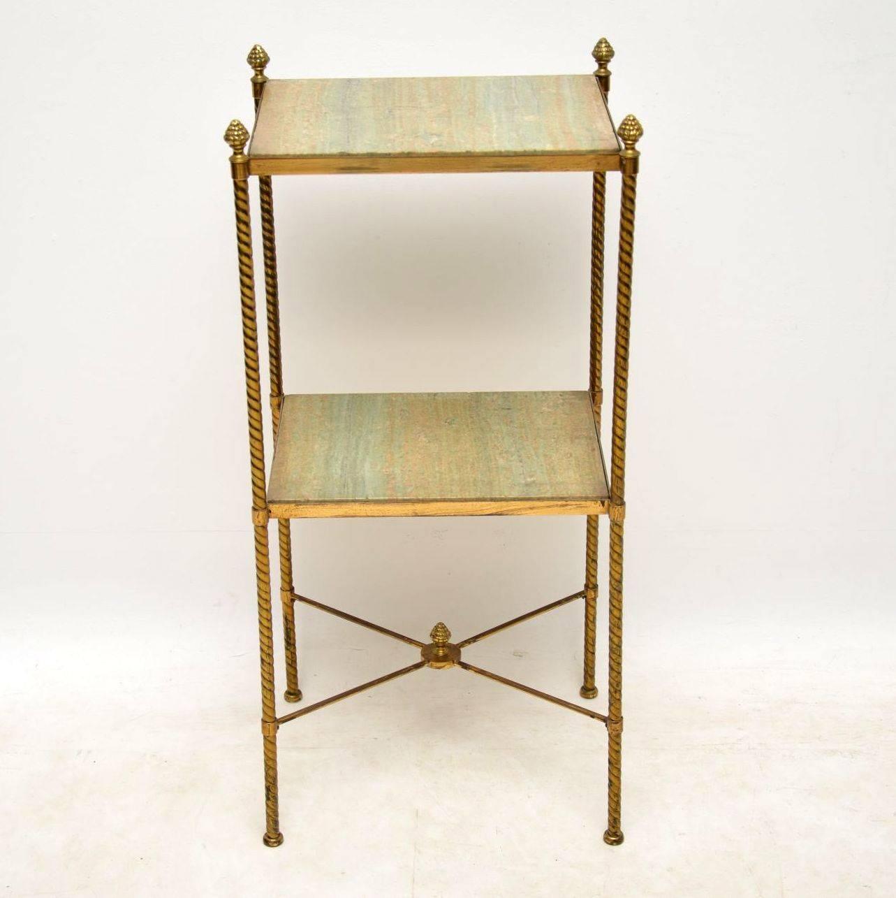 Antique French brass and marble two-tier table or stand. This is quite an unusual elegant piece of furniture and has lots of character. The four brass uprights have a king of spiral or barley twist design. There are brass finials on the tops and in