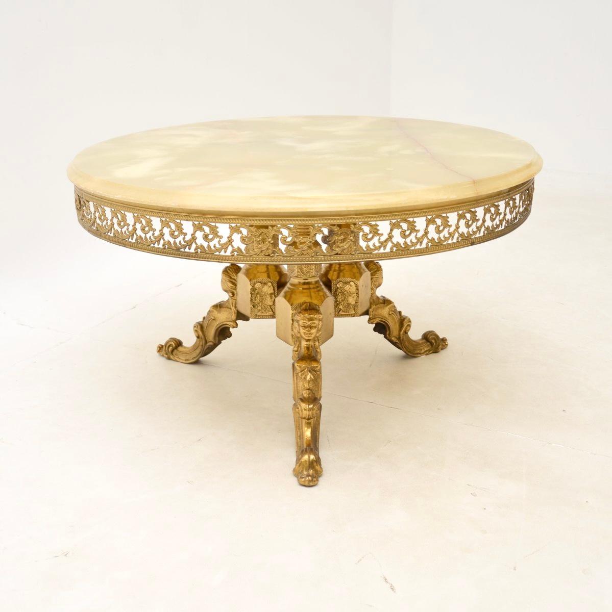 Magnifique table basse ancienne en laiton et onyx, datant des années 1930.

Il est de très bonne qualité et d'une taille très utile. Le grand plateau circulaire en onyx est d'une couleur magnifique. Il repose sur une base en laiton massif