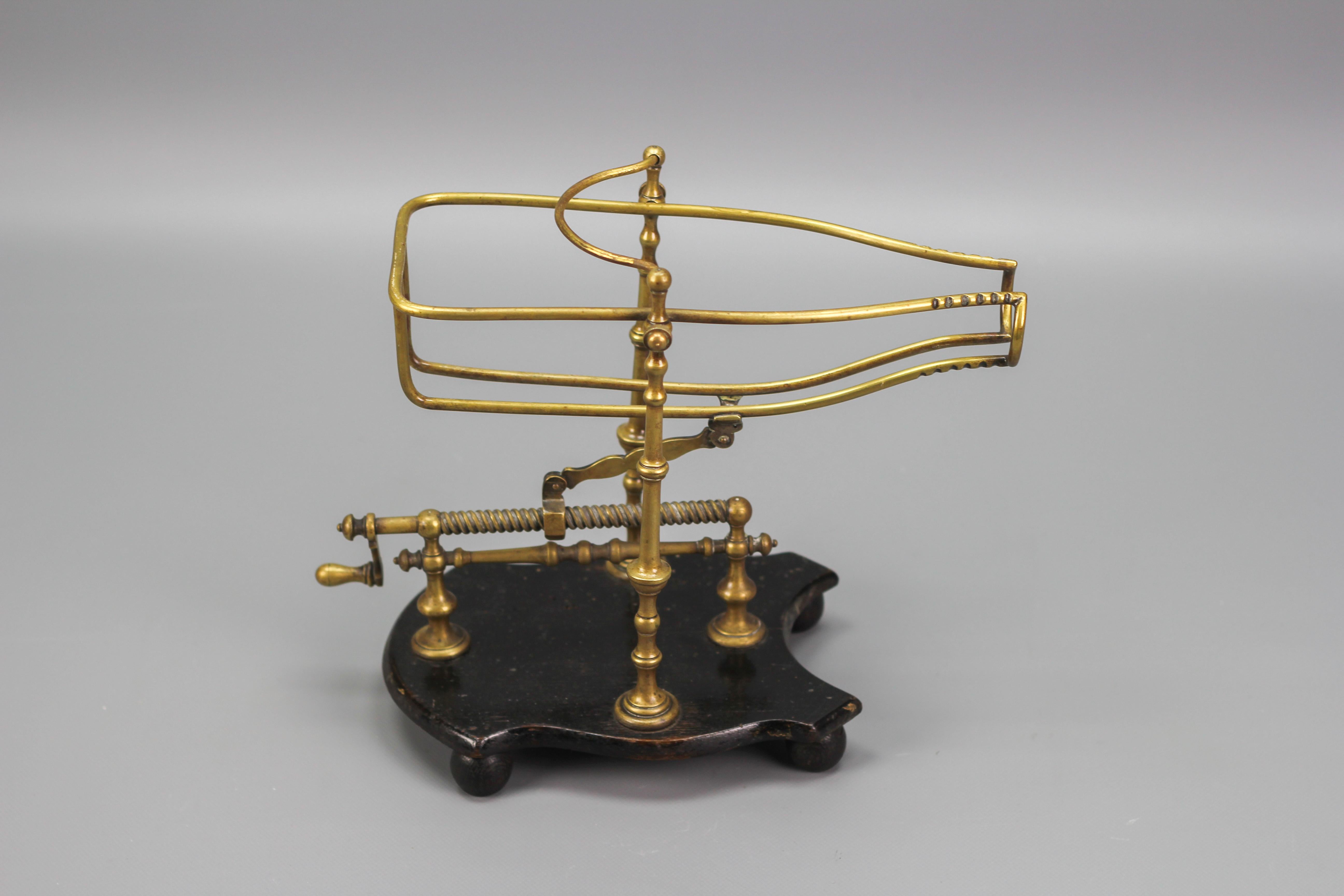 This brilliant device made in France circa the 1920s holds a bottle in a cradle attached to an adjustable spindle-turning handle. It is mounted on a shaped wooden base on four round feet. The cradle serves the purpose of pouring wine or other