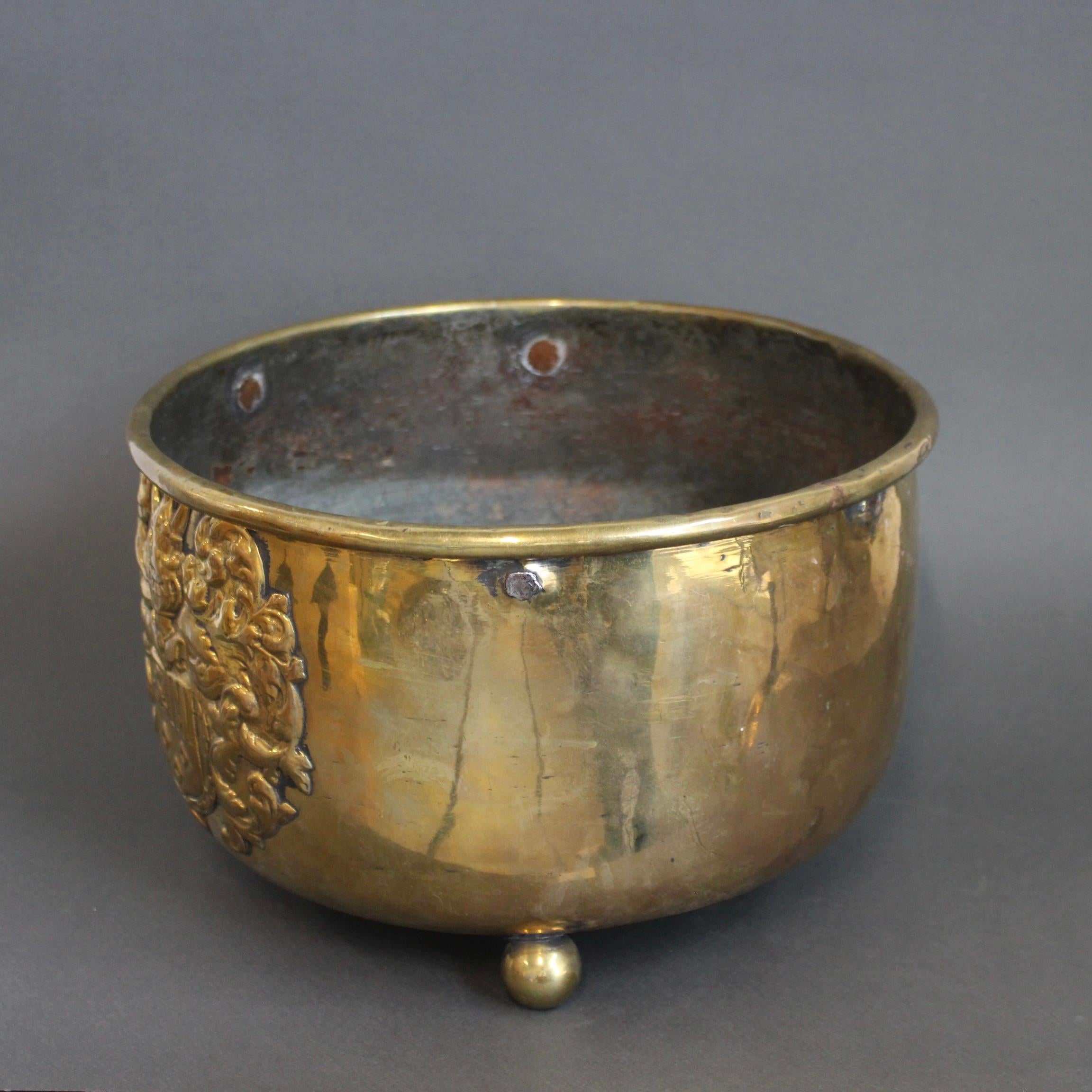 Antico cachepot francese a tre gambe in ottone (circa 1700). Questo pezzo ha un'affascinante connessione con i personaggi storici. Lo stemma laterale è una versione di quello appartenente alla famiglia del Duc de Villars, eroe militare francese