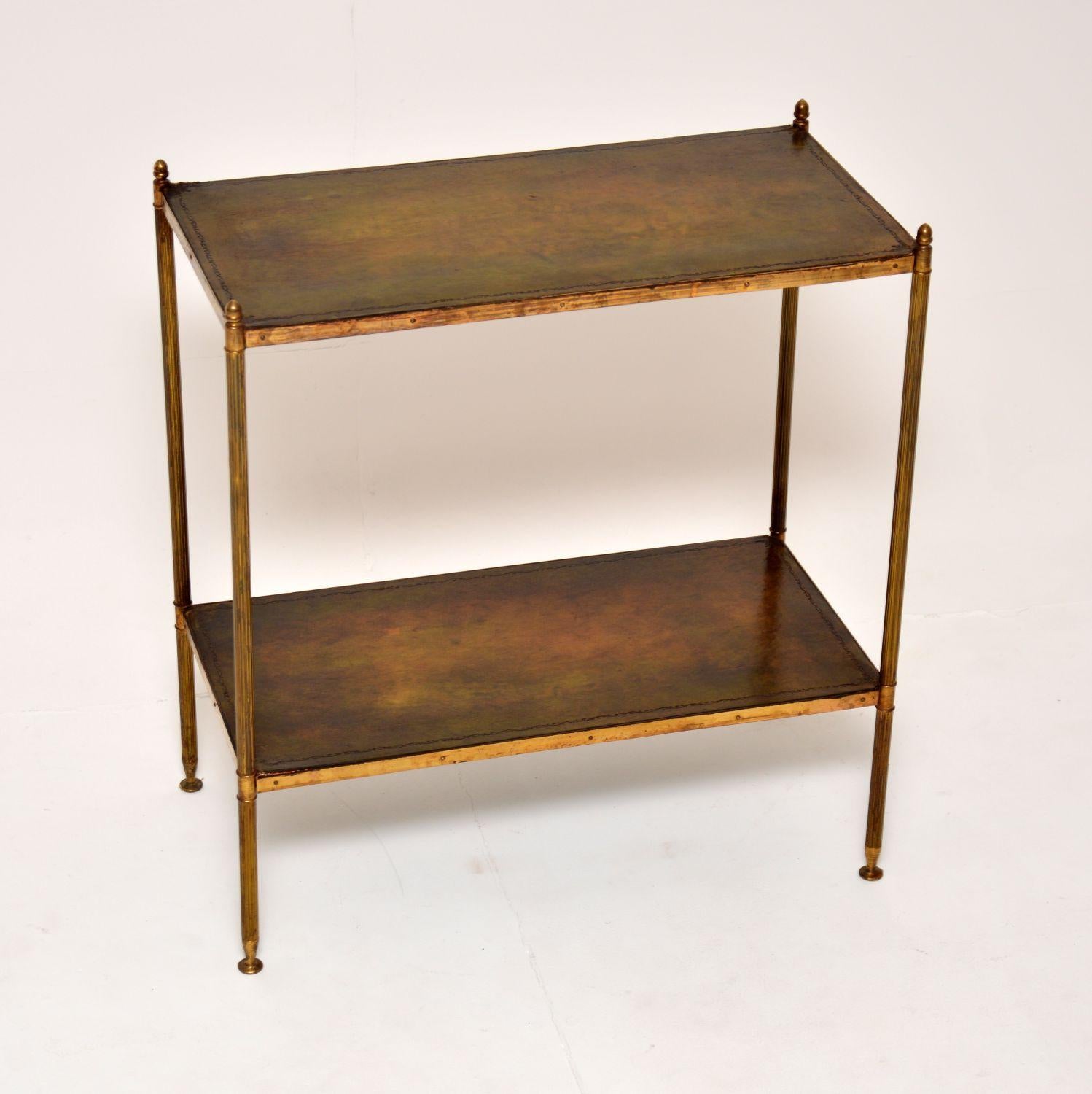 A smart and useful antique solid brass and leather two tier side table. This was made in France, it dates from around the 1930’s.

This is very well made, with finely fluted legs and acorn finials. It is finished identically front and back, so can