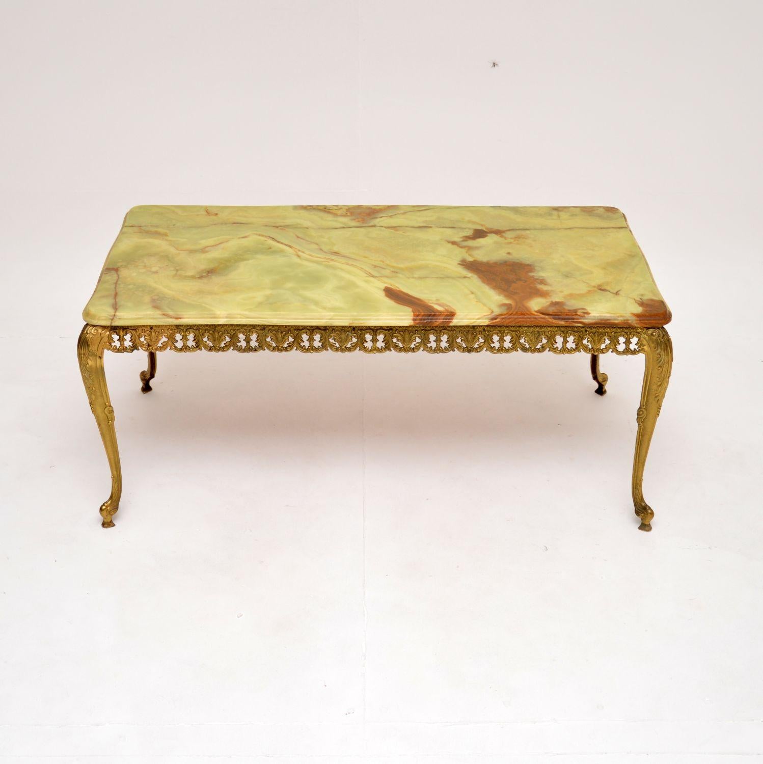 A beautiful and very well made antique French coffee table, dating from around the 1930’s.

It is of superb quality, the beautiful pierced brass frame has stunning details. This has an onyx top that sits on the base, the onyx has gorgeous colour