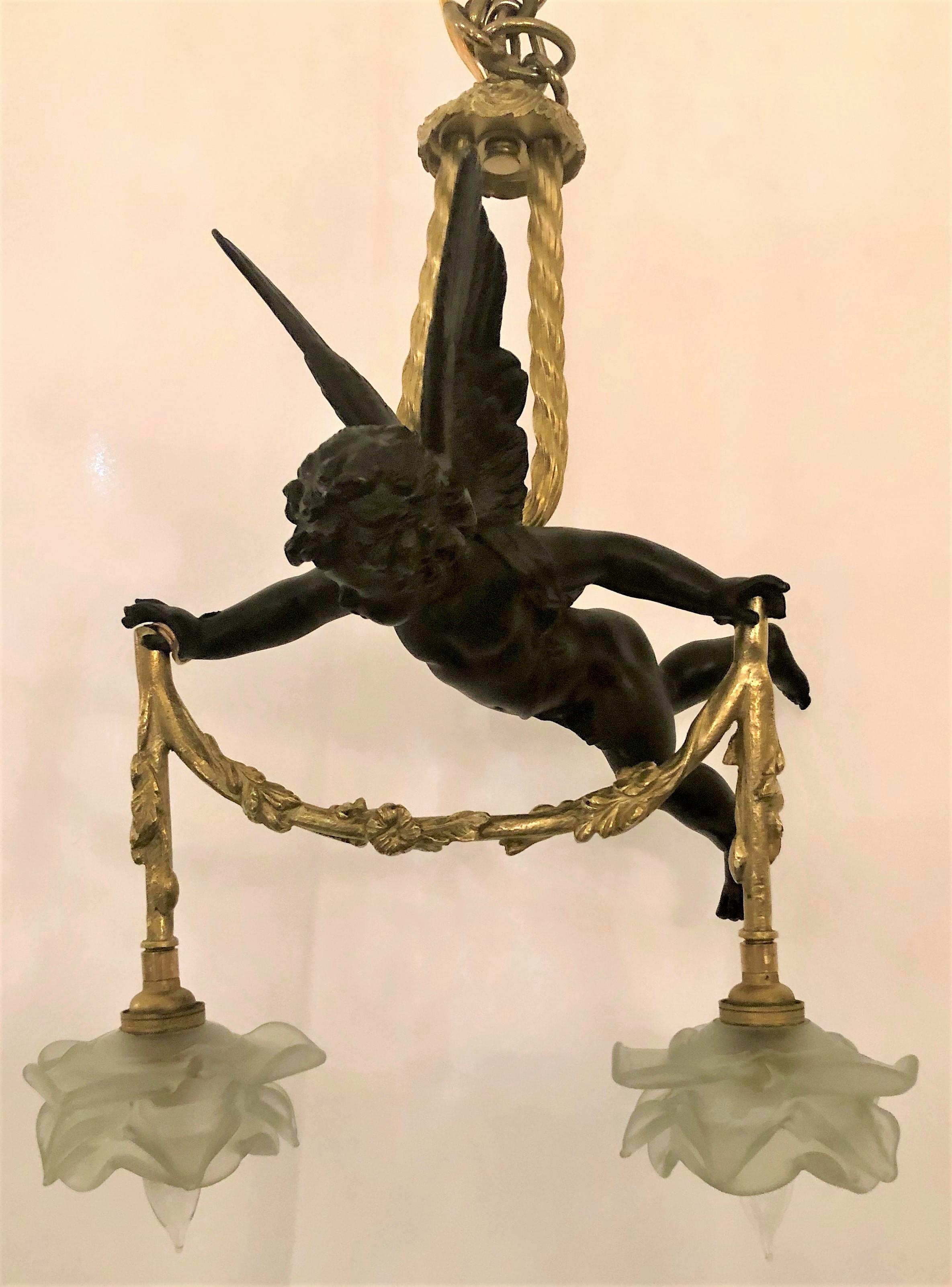 A charming chandelier with a cherub holding the lights.