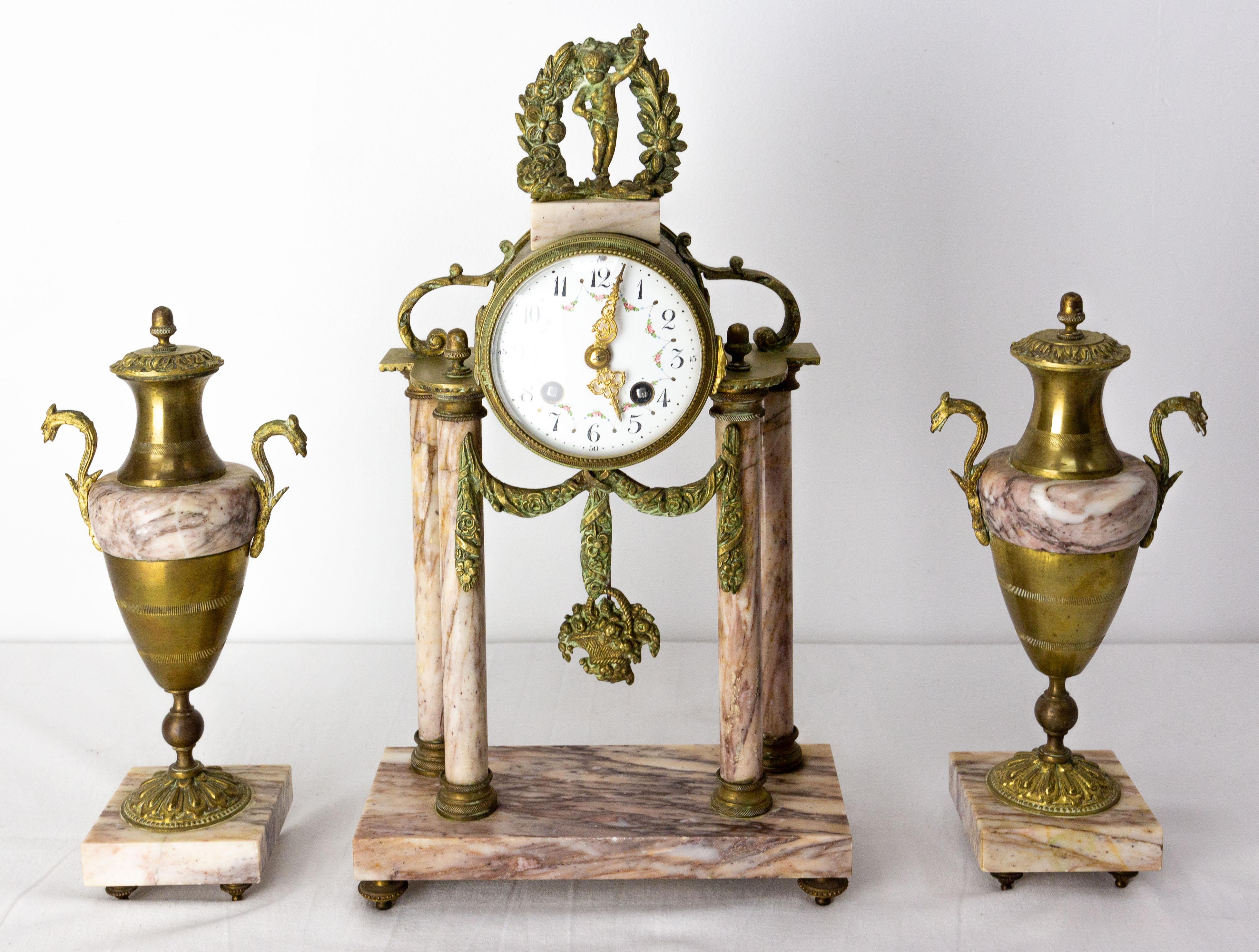 Napoleon III French gilded bronze mantel clock with putti cherub on the top of the clock late 19th century circa 1890.
Set of a clock and two amphoras.
Pendulum in the shape of a flower basket

The French movement of the clock will be checked