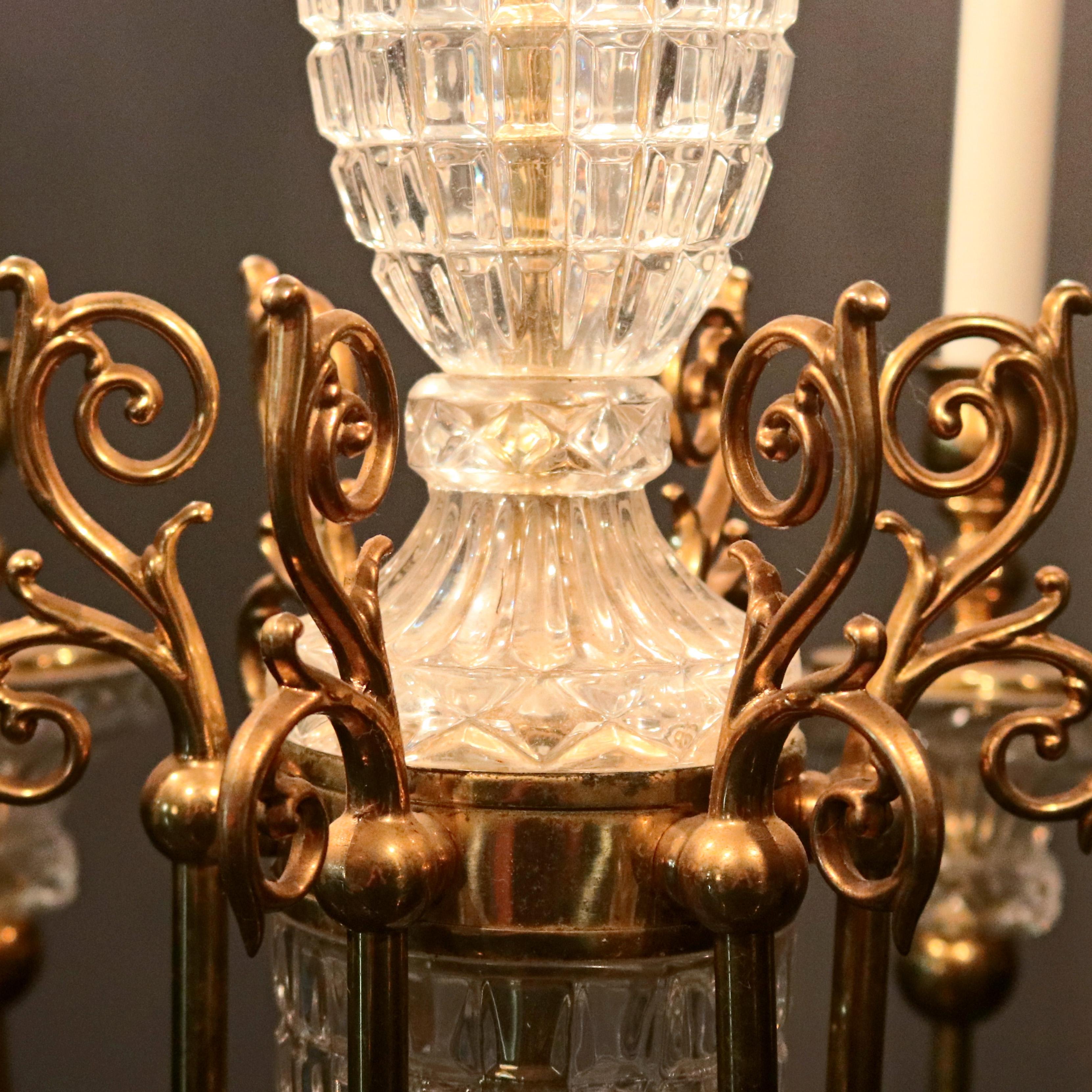 Antiker französischer Kronleuchter mit Bronzerahmen, Kristall und gegossenen Blattwerk- und Rollenelementen mit sechs C-Rollenarmen, die in Kerzenlichtern enden, um 1930


Maße: 12