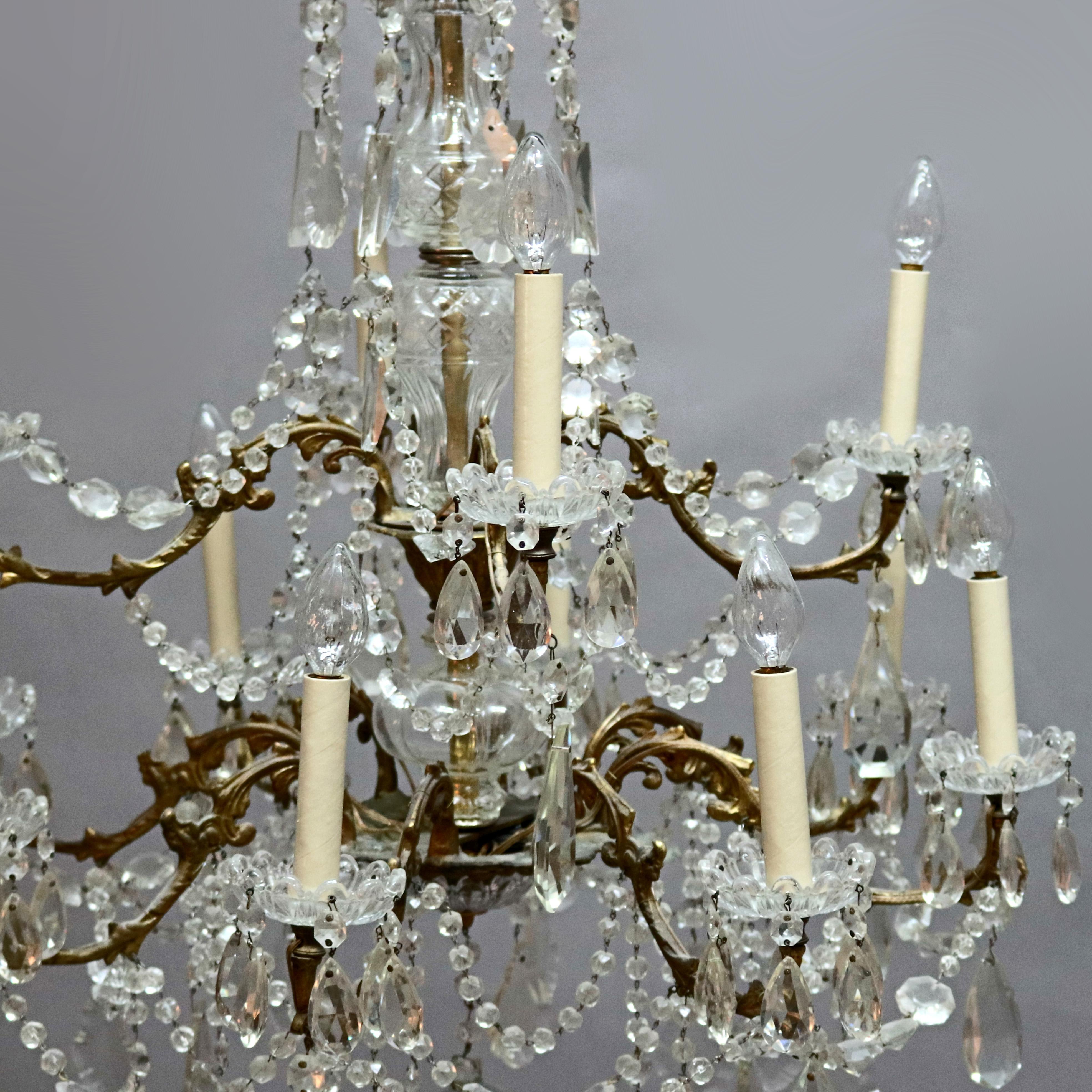 An antique French chandelier offers bronze frame in tiered form with twelve branch form arms terminating in candle lights, strung and drop cut crystals throughout, wired for US electricity, circa 1920

Measures: 36