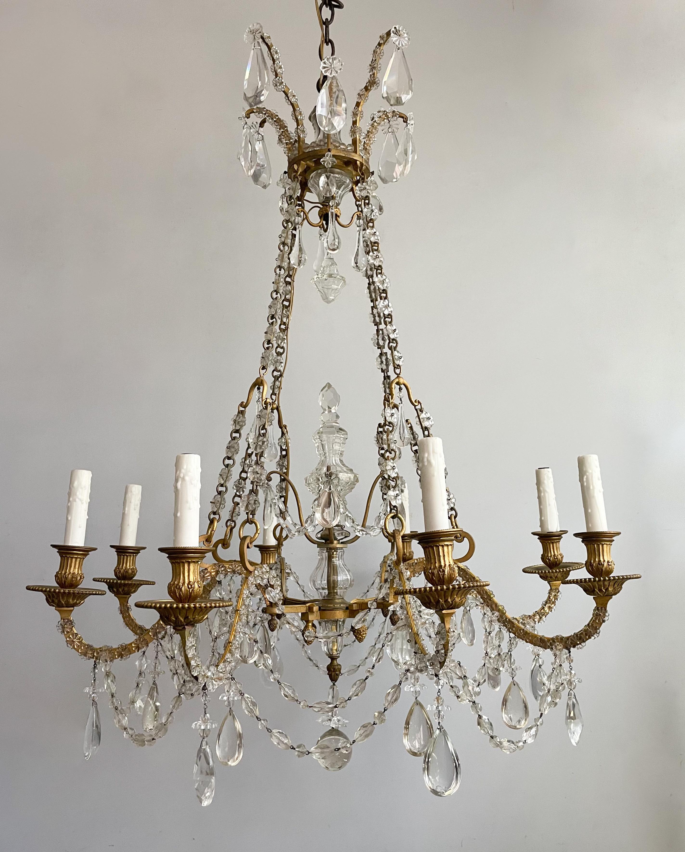 Exquisite, antique French bronze-doré and crystal chandelier in the Empire style. 

The chandelier features a gilt-bronze base suspended by chains that taper up to a delicate crown-shaped top. The entire chandelier is embellished with crystal