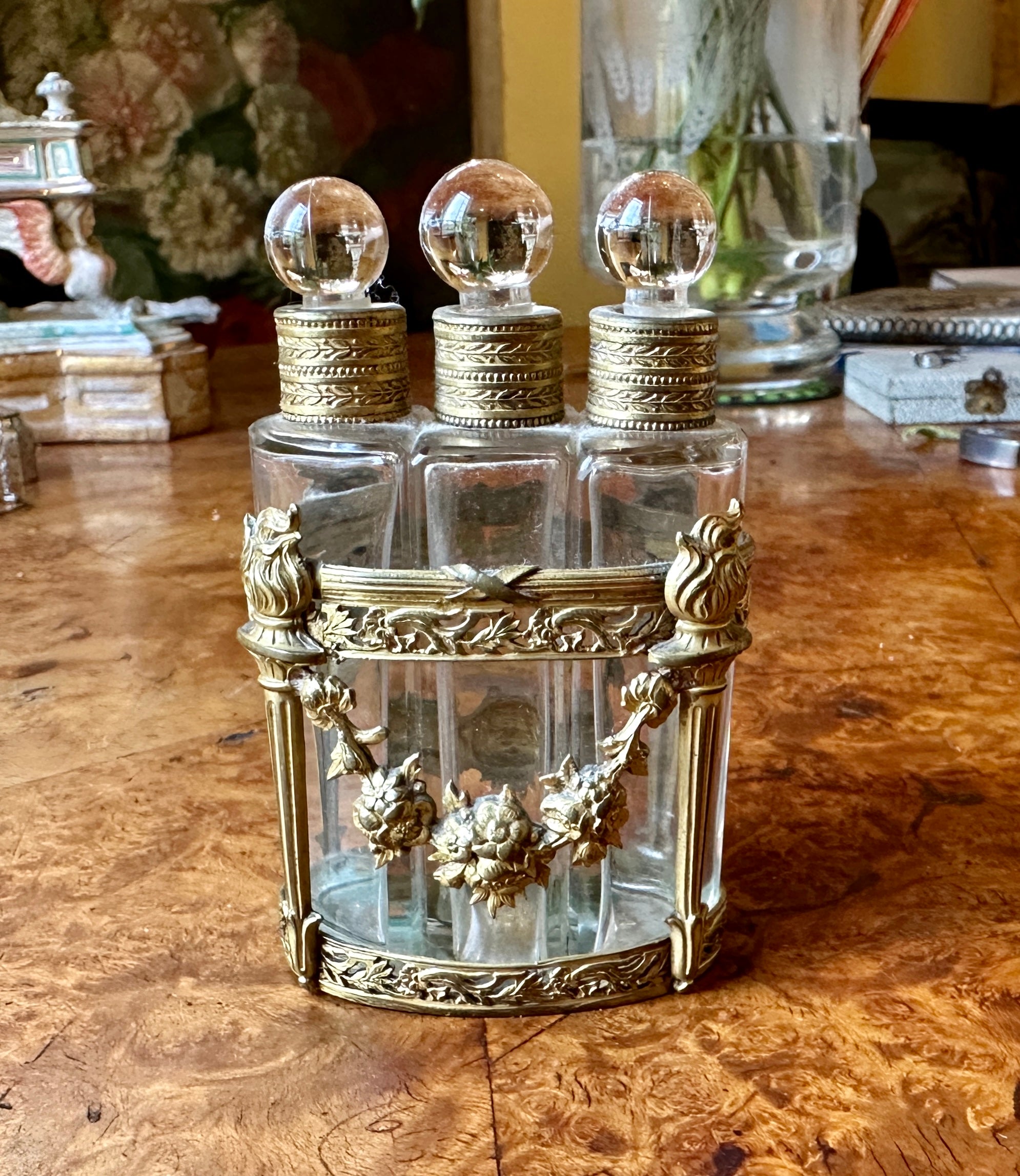 This is a gorgeous antique French Bronze Dore triple perfume bottle caddy set dating to circa 1860-1890.  The set is composed of a found ormolu gilt bronze carriage in cast and gilt bronze with three glass fitted bottles with round stoppers. The
