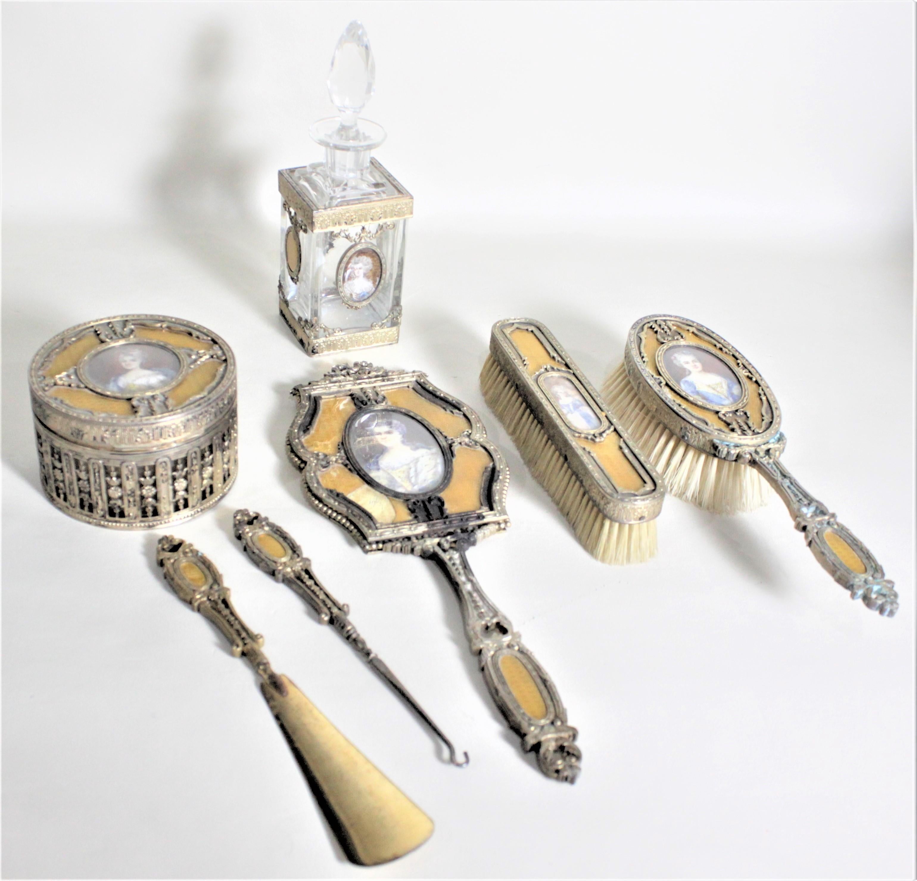 This antique ladies dresser set has no maker's marks but presumed to have been made in approximately 1900 in the 'Louis XVI' style. This seven piece set includes two brushes, a handled mirror, a dresser box, a scent or perfume bottle, and a shoe