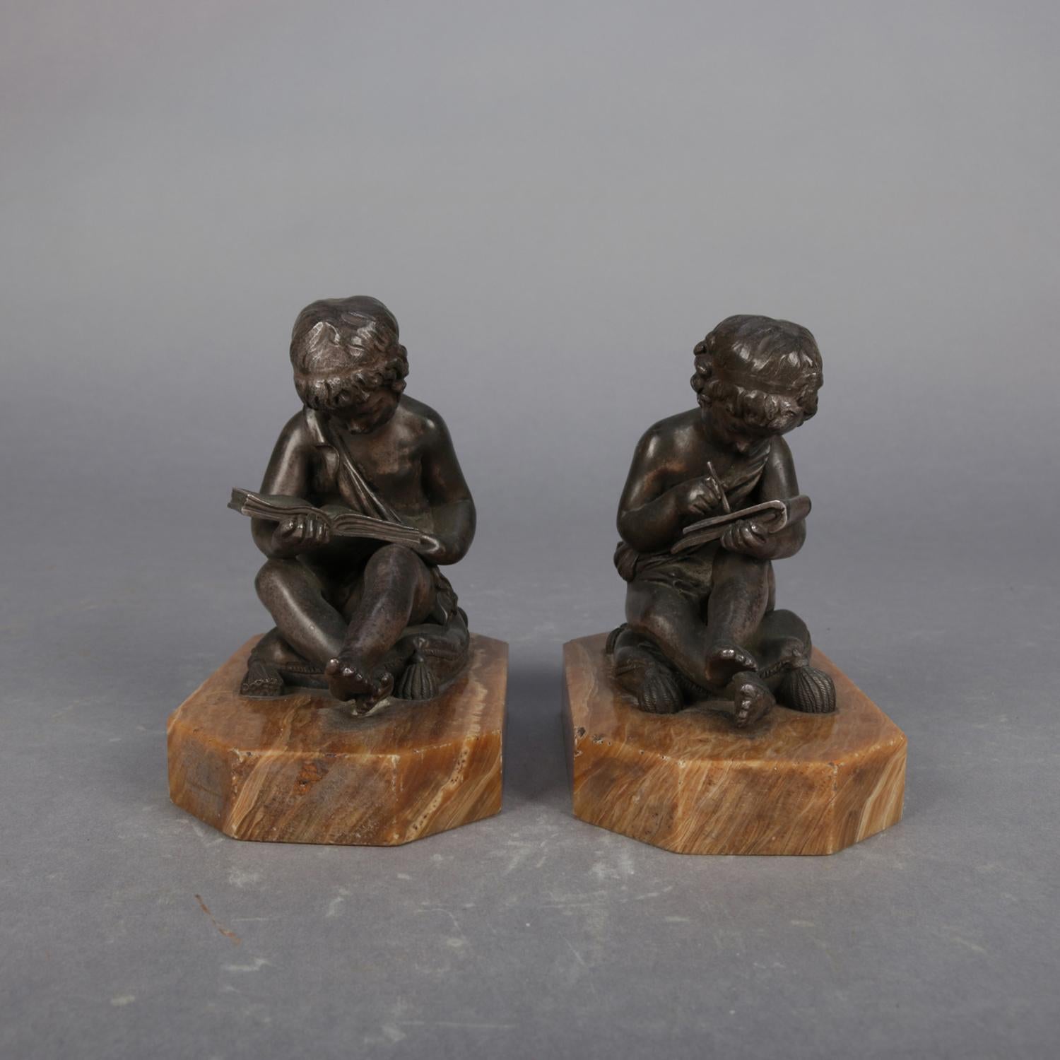 Antique pair of figural bronze sculpture bookends representing children, one reading and one writing while seated on tasselled cushions, signed Lemire (Charles Gabriel Lemire, French, 1741-1827) and bearing foundry stamp seal JOLLET et Cie et COLIN