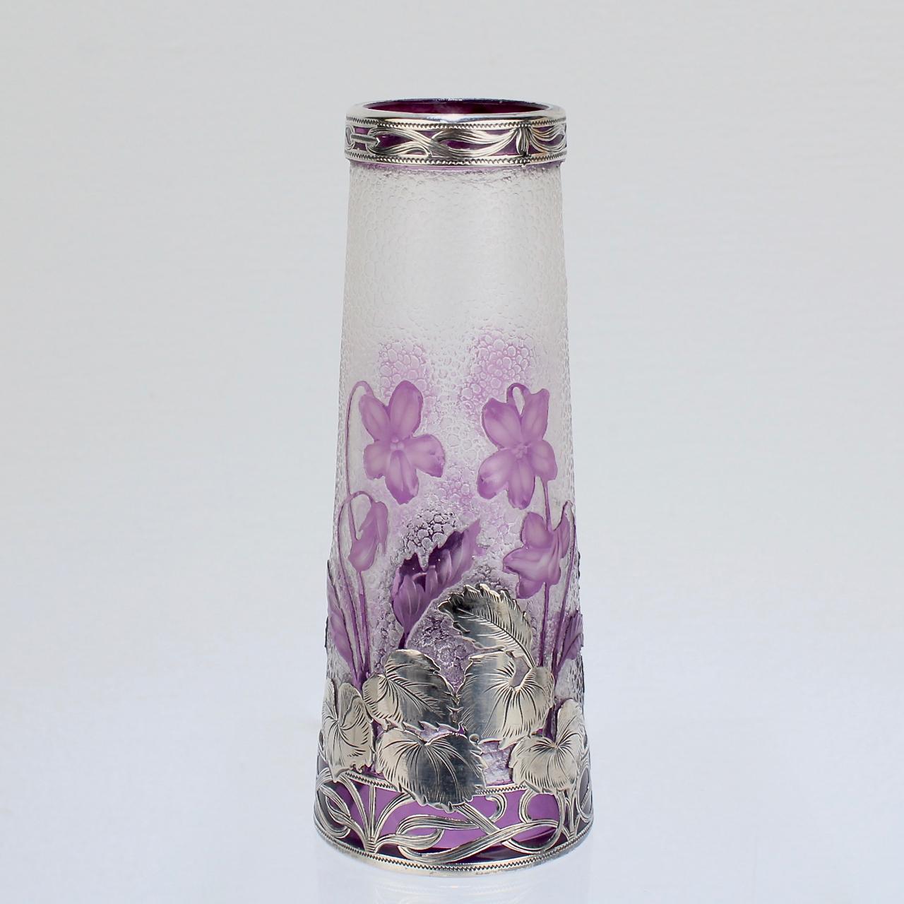 A very fine antique French cabinet-size art glass cameo vase. 

With purple violet flowers and leaf cameo design on a clear ground and a secondary silver overlay to the base and rim. 

Attributed to Burgun & Schwerer Cie.

Unmarked for silver