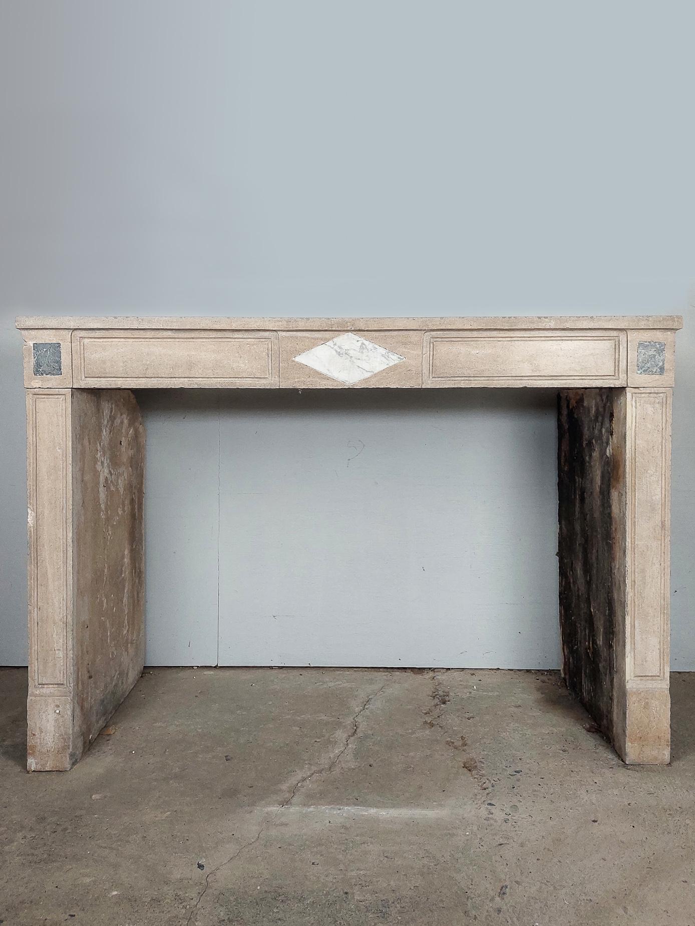 Antique French natural stone fireplace. 19th century mantelpiece made of burgundian stone (Pierre de bourgogne) in beige / sand tones. This fireplace is decorated with a diamond shape of inlaid Bianco carrara and square inlays of St. Anna marble at
