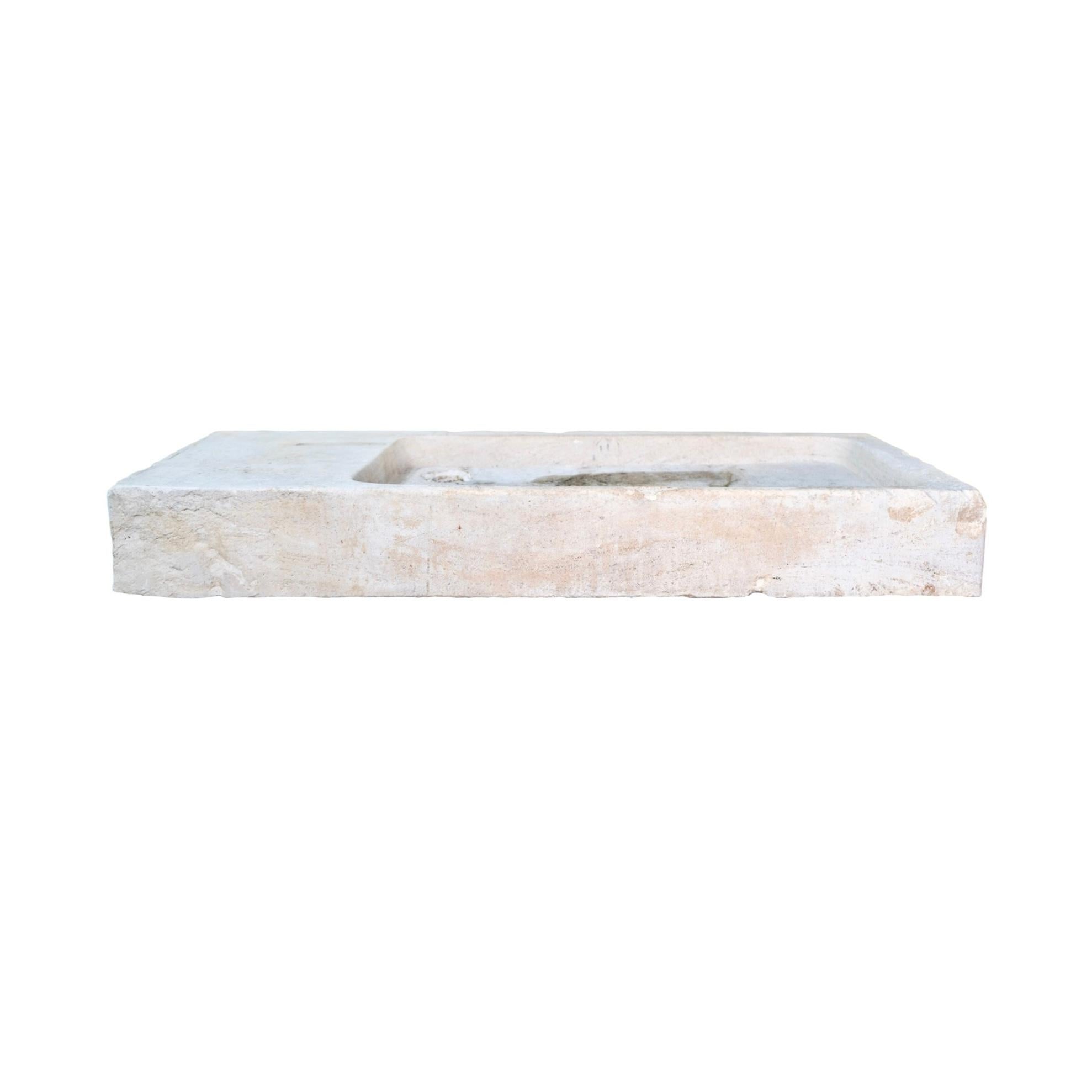 Fregadero francés del siglo XIX fabricado en piedra caliza burdeos, con un característico diseño rectangular ancho de perfil bajo. Rica en carácter, su pátina envejecida y su desgaste natural muestran su historia. La pila tallada del lavabo se