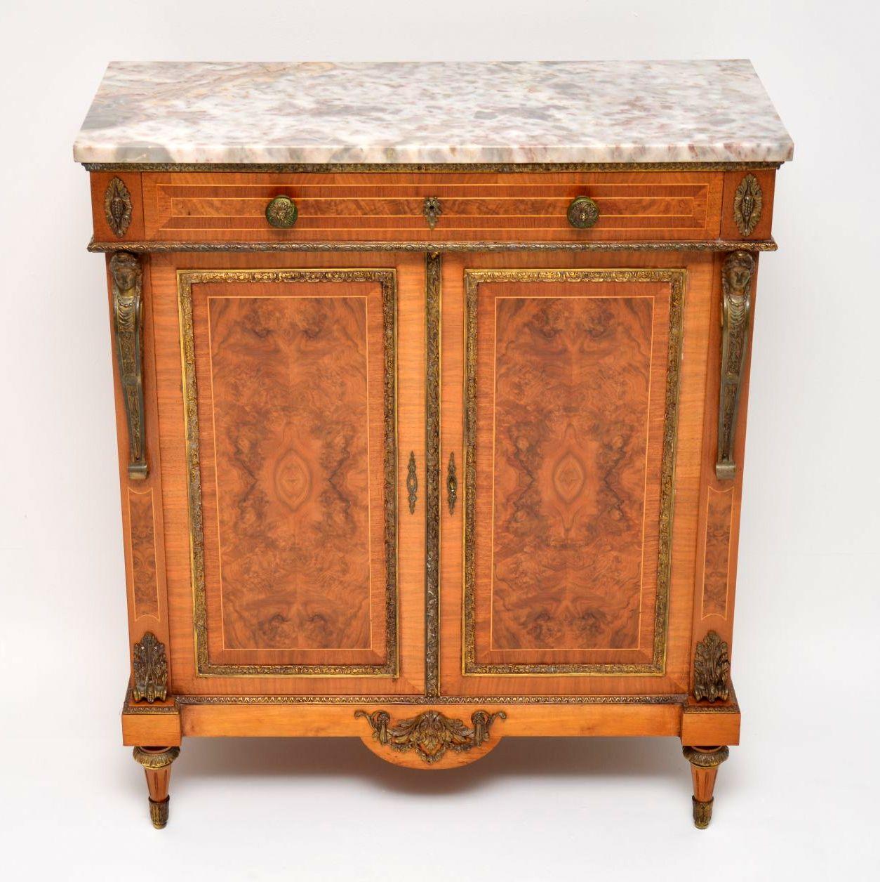 This antique French marble-top cabinet is fabulous quality, in great condition and has some great features. It’s mainly burr walnut on the front and the sides, with figured walnut and kingwood bandings, plus some satinwood inlays. There are gilt