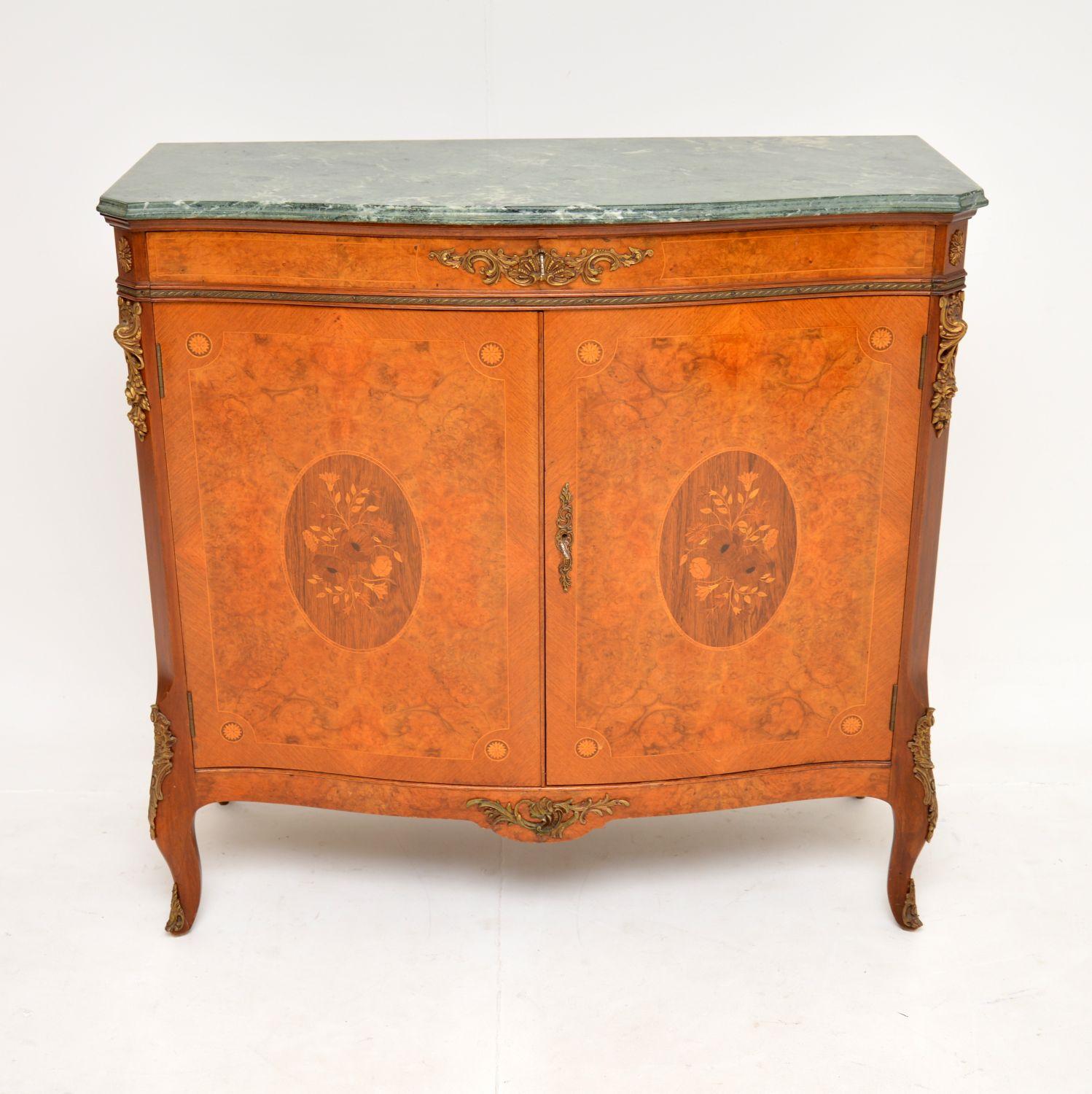 A beautiful antique French marble top cabinet in burr walnut, this dates from around the 1930’s.

It is of superb quality, with gorgeous burr walnut grain patterns. The doors have inlaid wood panels with floral patterns, there are also fine quality