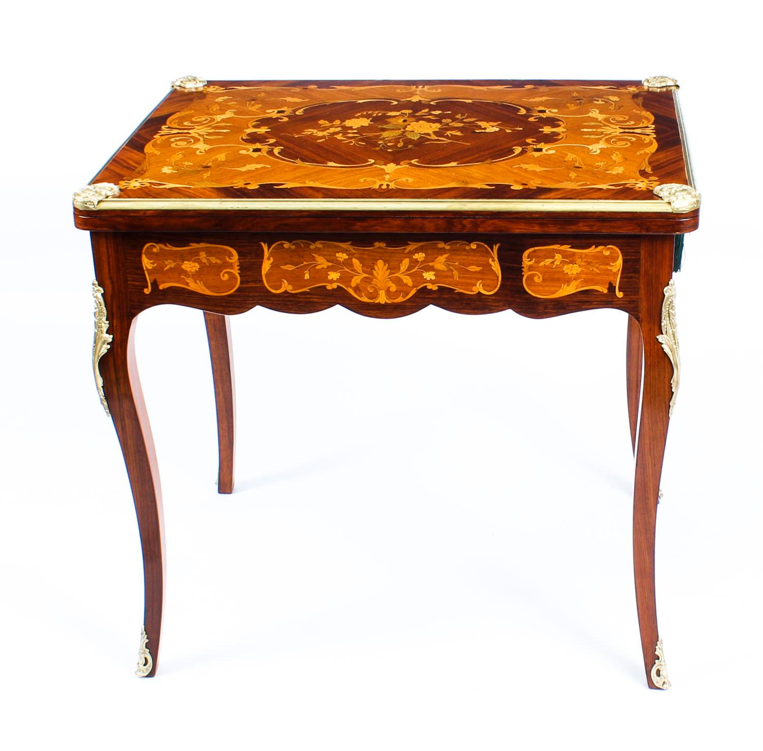 A truly fabulous antique French marquetry turnover top games table, circa 1880 in date.

The top with ormolu banded edge, the floral marquetry decoration exhibits a stunning array of exotic woods to include walnut, satinwood, and tulipwood.

The