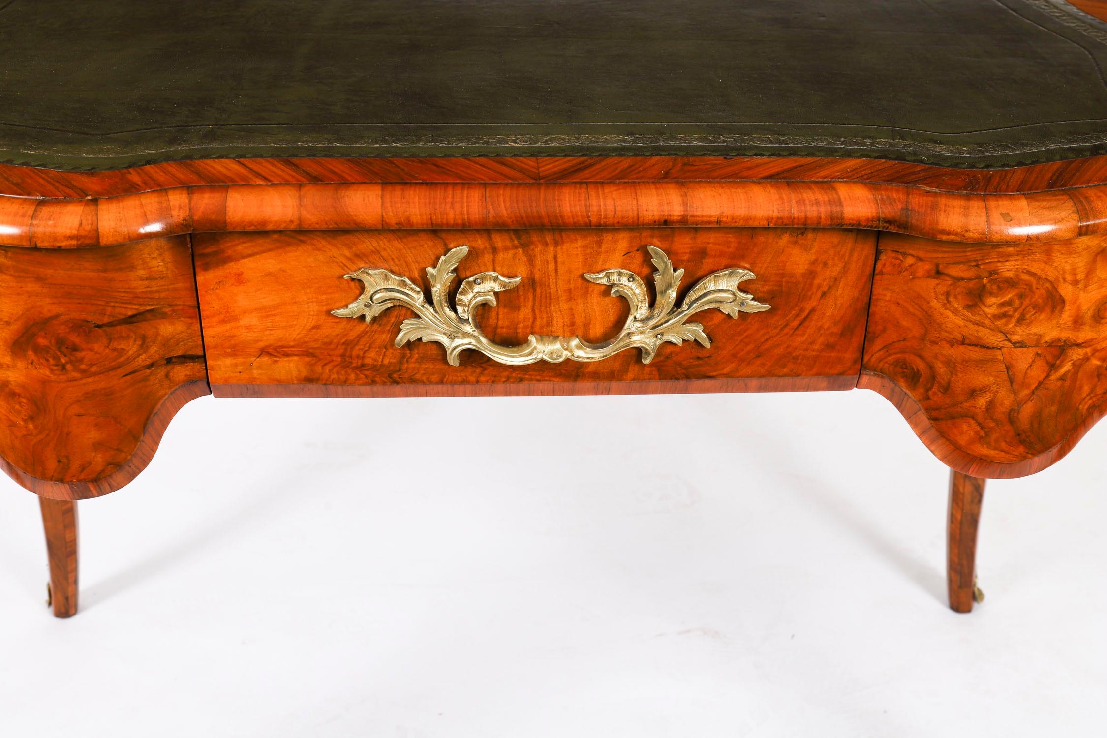 A gorgeous antique French ormolu mounted burr walnut library table, circa 1870 in date.

Featuring king wood banding, the shaped top with an inset gold tooled green leather writing surface and decorative ormolu mounts, this table is sure to get
