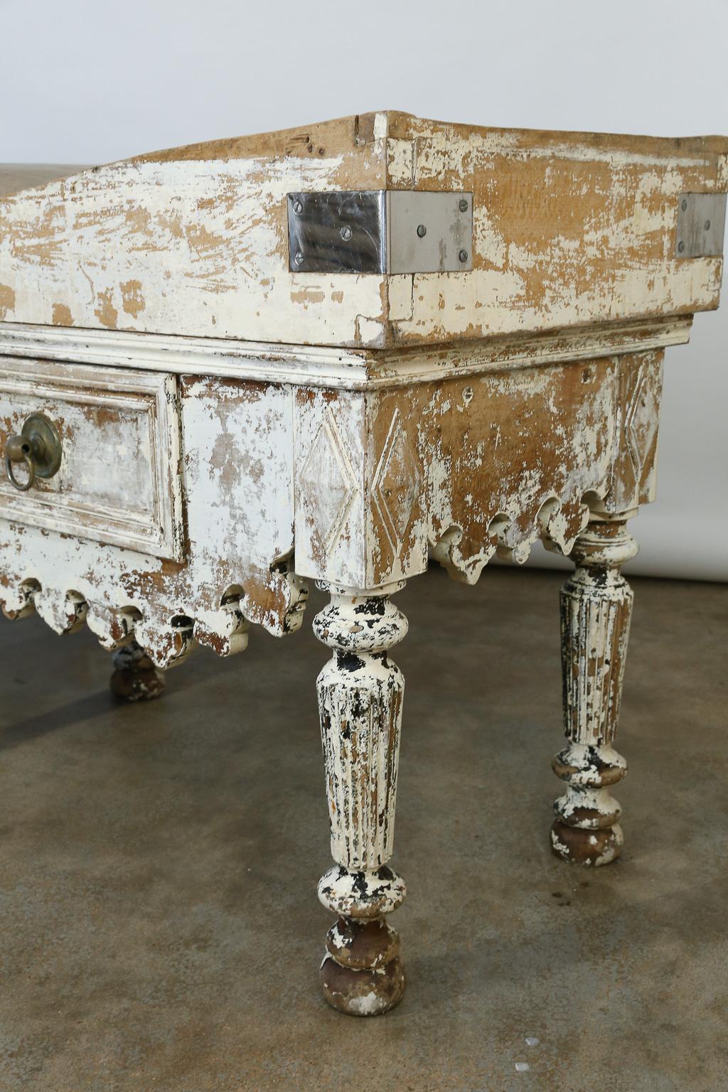 This late 19th century French butcher table features a beautiful marble top, a well used butcher block and three drawers for storage. The marble top measures 28