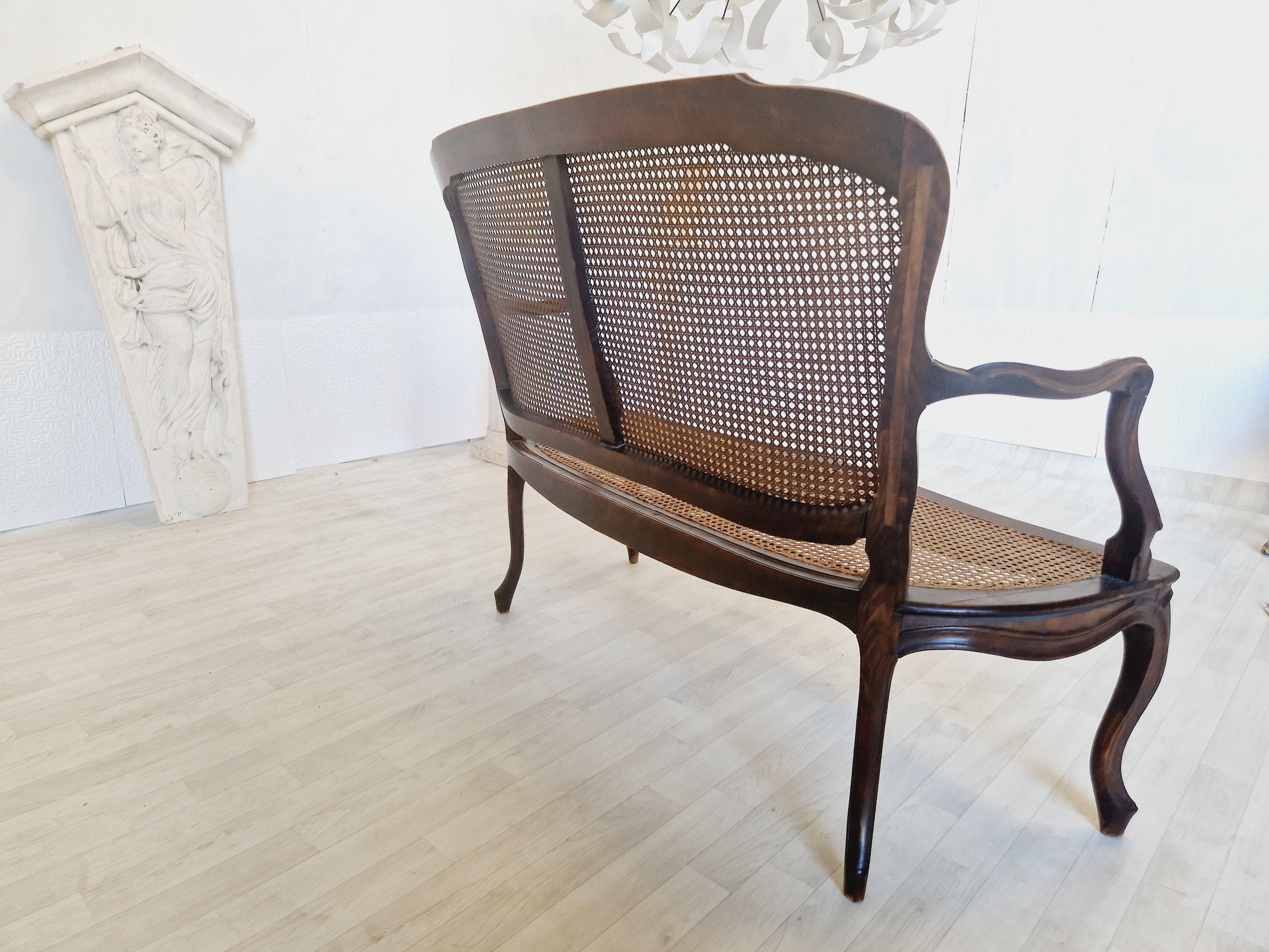 Lassen Sie sich vom Charme des 19. Jahrhunderts verzaubern mit diesem eleganten französischen Rocaille-Salon-Set. Dieses aus hochwertigem Nussbaumholz gefertigte Set mit Sitz und Rückenlehne aus Rohrgeflecht im Louis XV-Stil besteht aus einem Sofa