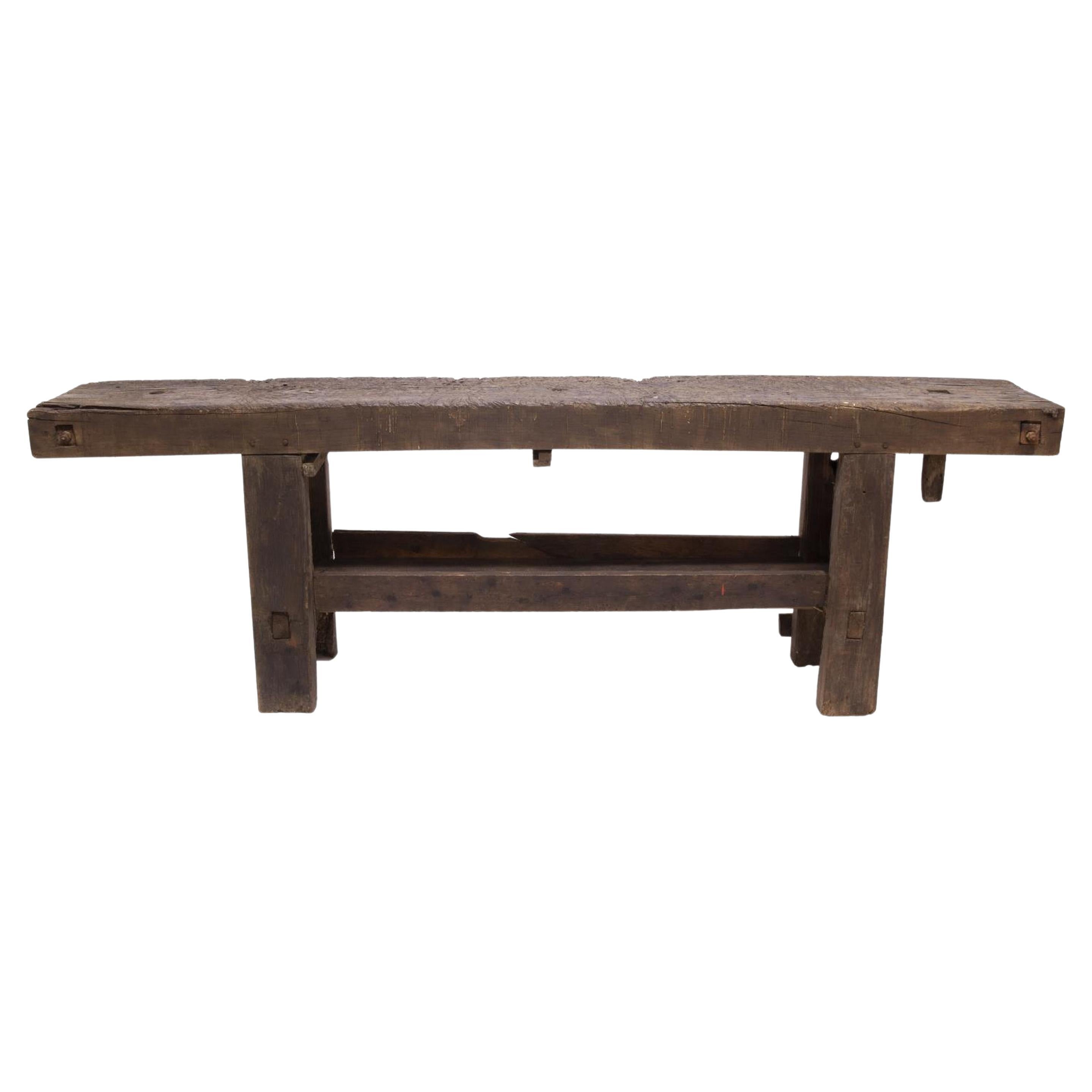 A classic 19th century French carpenter's table. It features a four inch thick top showing original saw markings and nail holes, creating a gorgeous patina that illustrates it's active use over many years by a French artisan carpenter. A heavy