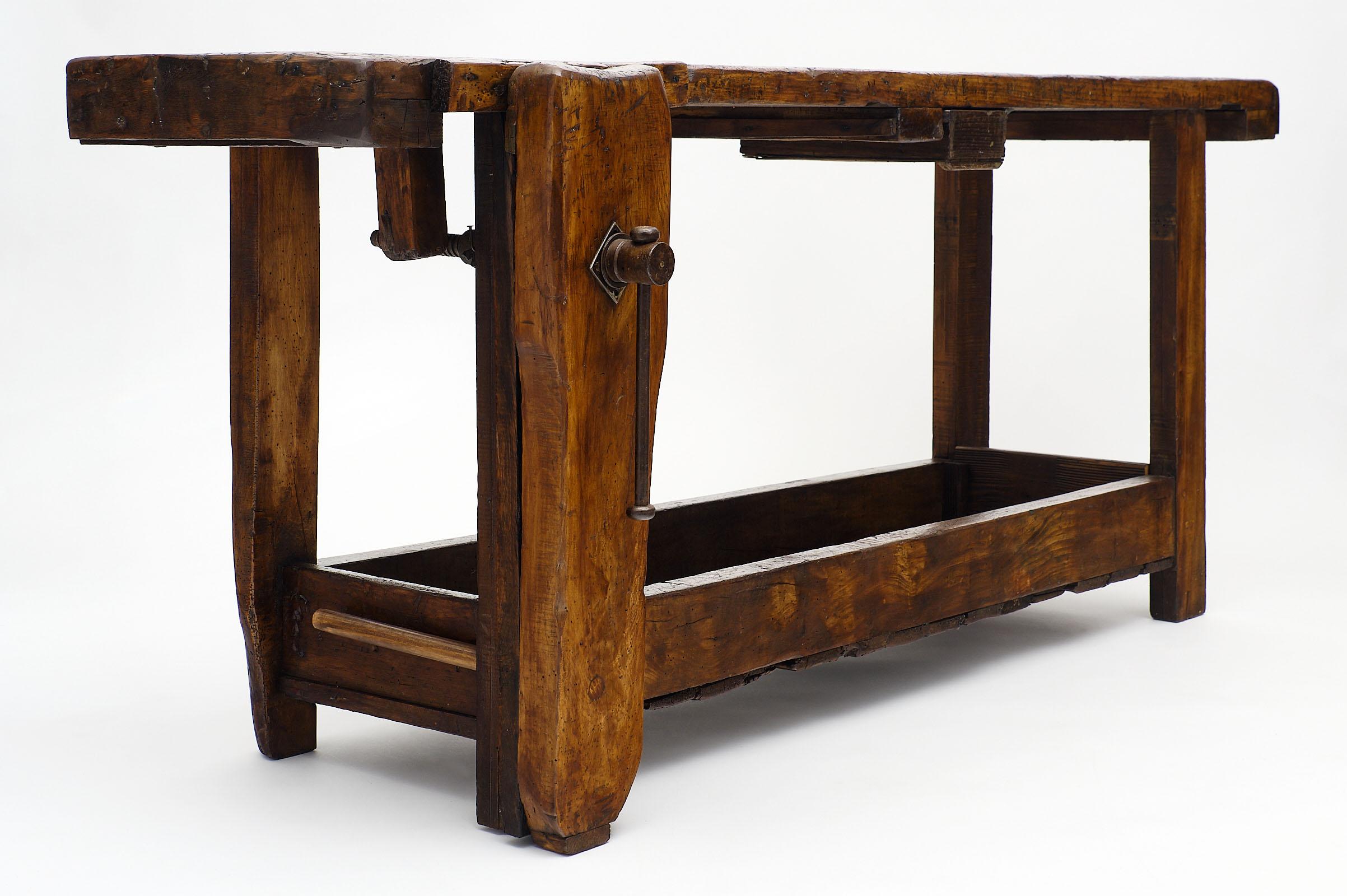 French antique carpenters workbench of chestnut featuring its original vise and shelf. These pieces were used in the winter by French peasants who would become occasional craftsmen while they could not harvest.