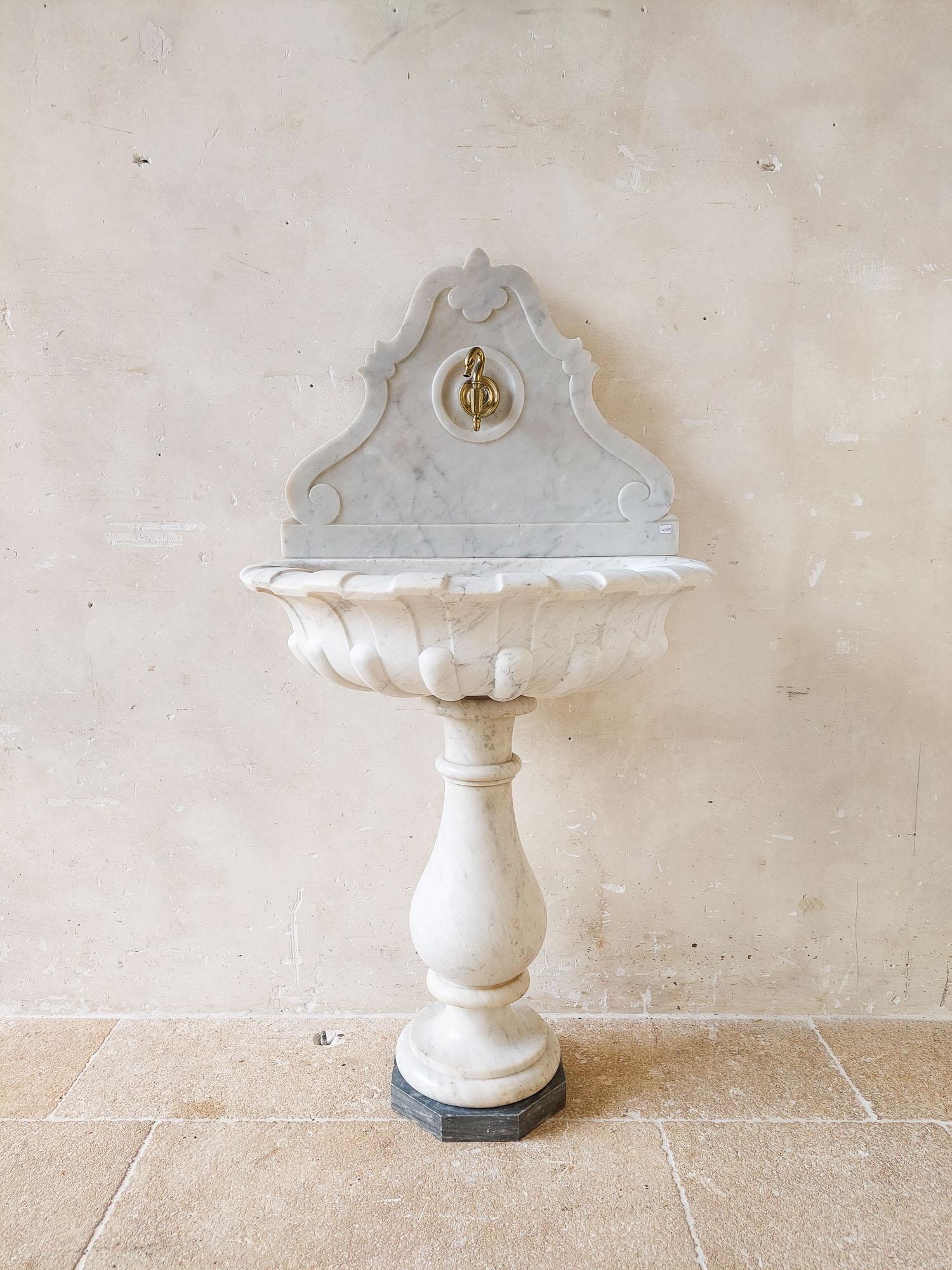 Antique French marble wall fountain, ± 1770. Beautiful Carrara marble wall fountain with marble wall plate behind the lobed bowl-shaped sink, on baluster base with Bardiglio marble base.

dimensions: h 125 x w 65 x d 51 cm
sink height: 79