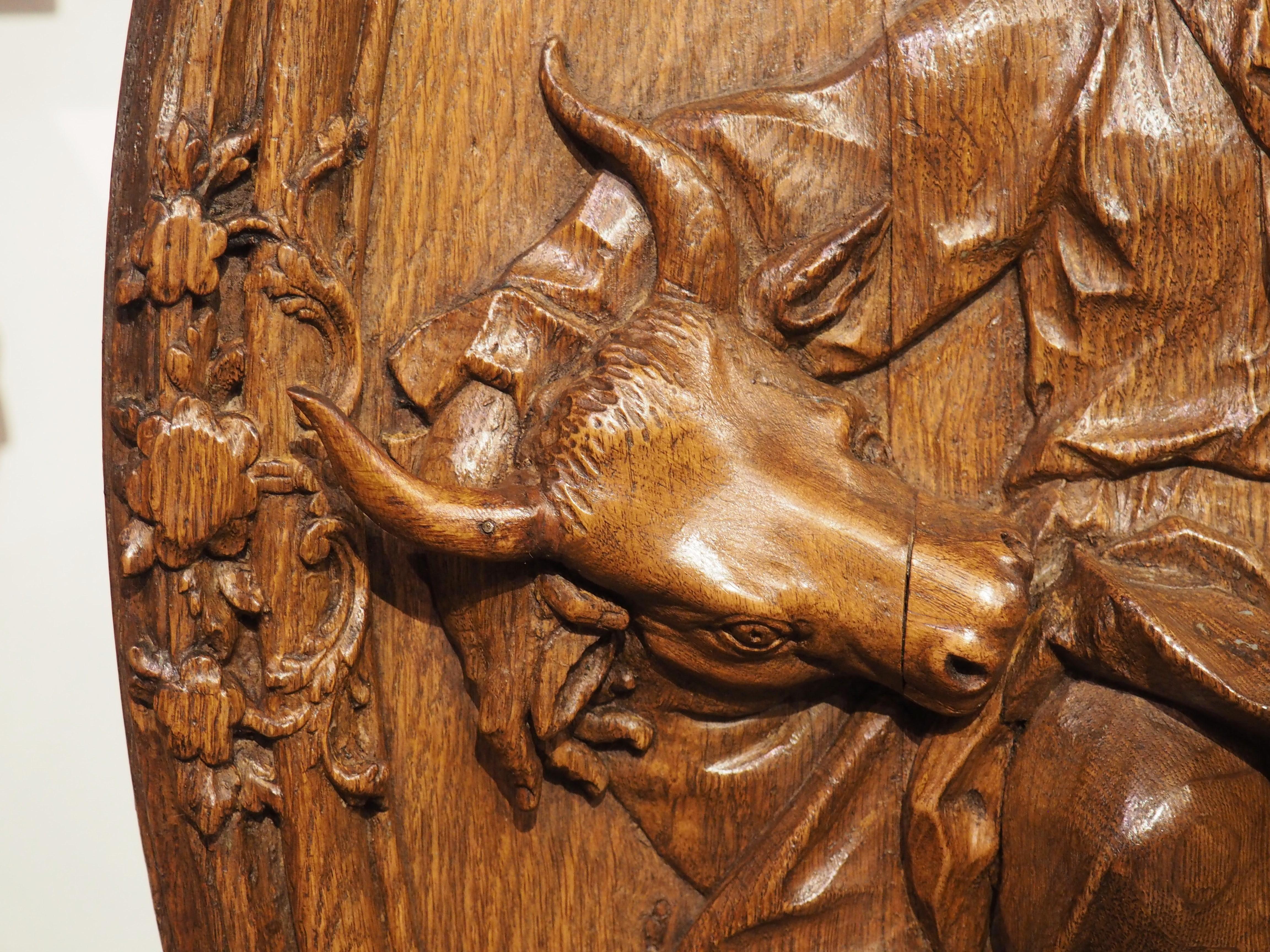 Magnifique démonstration de maîtrise du travail du bois, cette plaque ovale antique de saint Luc a été non seulement sculptée en bas-relief, mais elle a aussi une forme incurvée. La plaque concave présente plusieurs anneaux de bordures en quart de