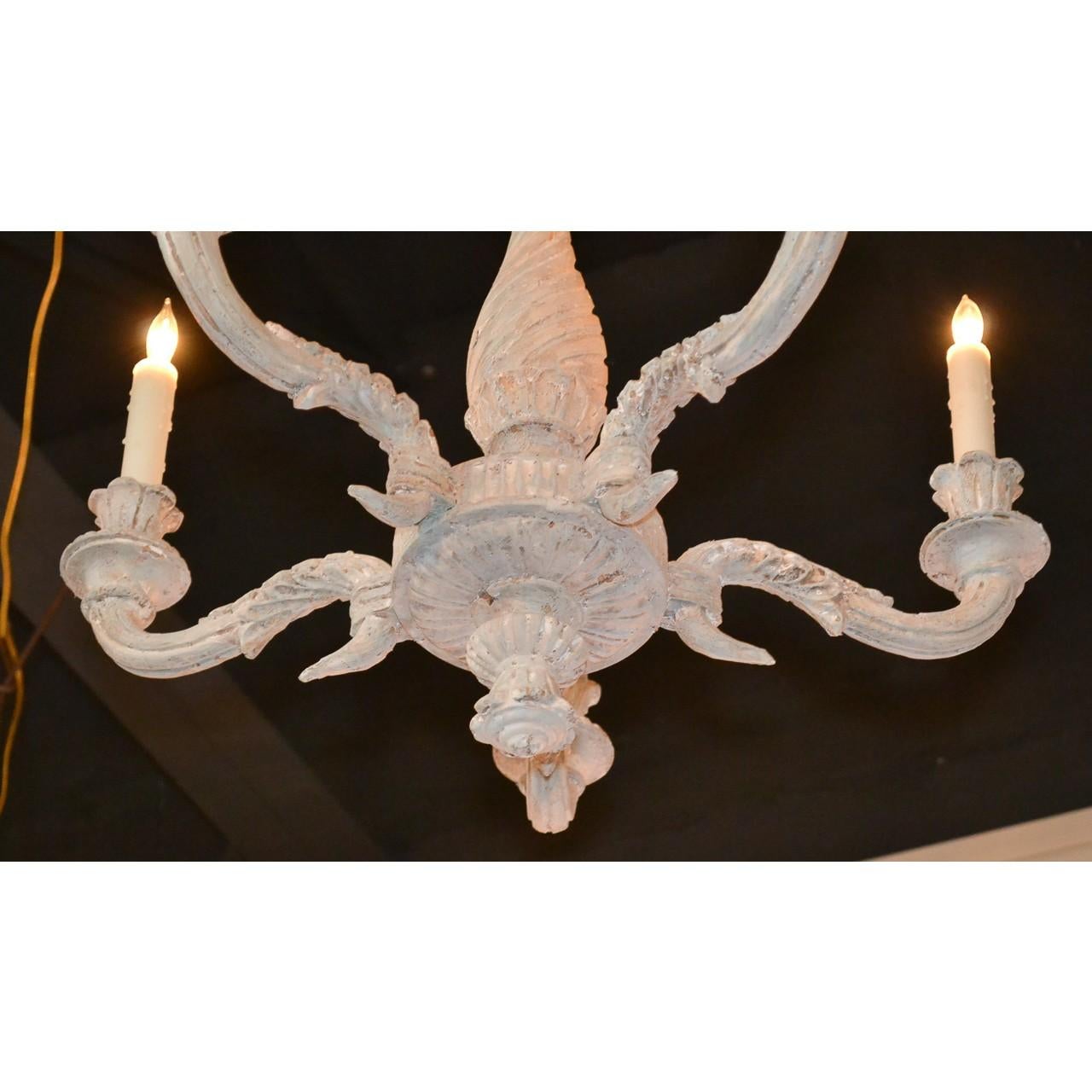 Understated antique French hand-carved and painted chandelier. The shaped and tapered stem carved in a twist and flute design and mounted with four foliate motif scrolling arms having flower cup candle holders. Electrified,

circa 1900.