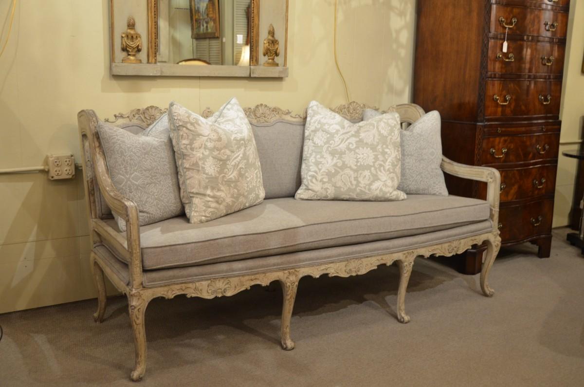 Antique French carved and painted grisaille upholstered sofa.