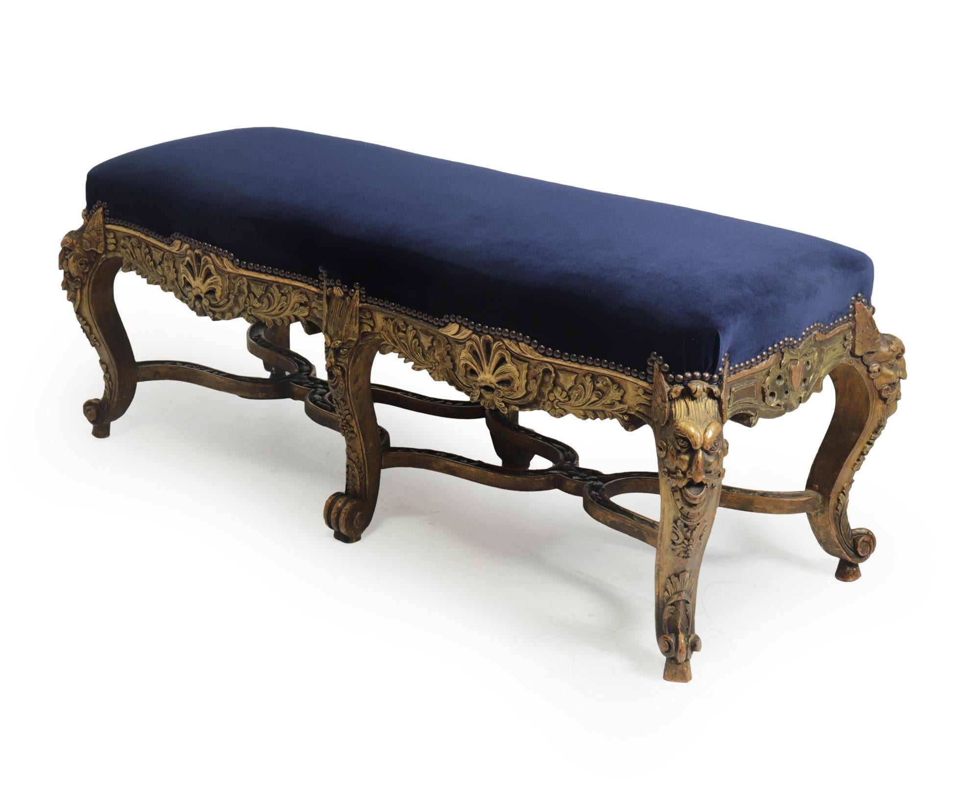 Antique French carved and parcel gilt long stool, c1860
Elegant and fine French baroque style ornately carved gilt wood stool, serpentine in form. It features cabriole legs on scroll feet decorated with scrolls and acanthus leaves, six grotesque