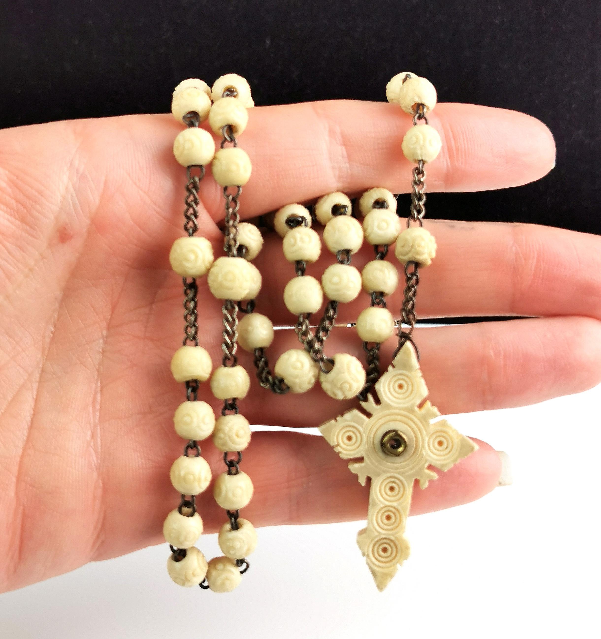 An attractive antique French carved bovine bone rosary bead necklace with a carved bone Cross pendant.

The cross pendant has a Stanhope to the centre showing a religious image possibly of Mary, the glass sits slightly skew so you need to view at an