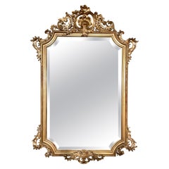Miroir ancien en bois doré sculpté et biseauté, Circa 1860.