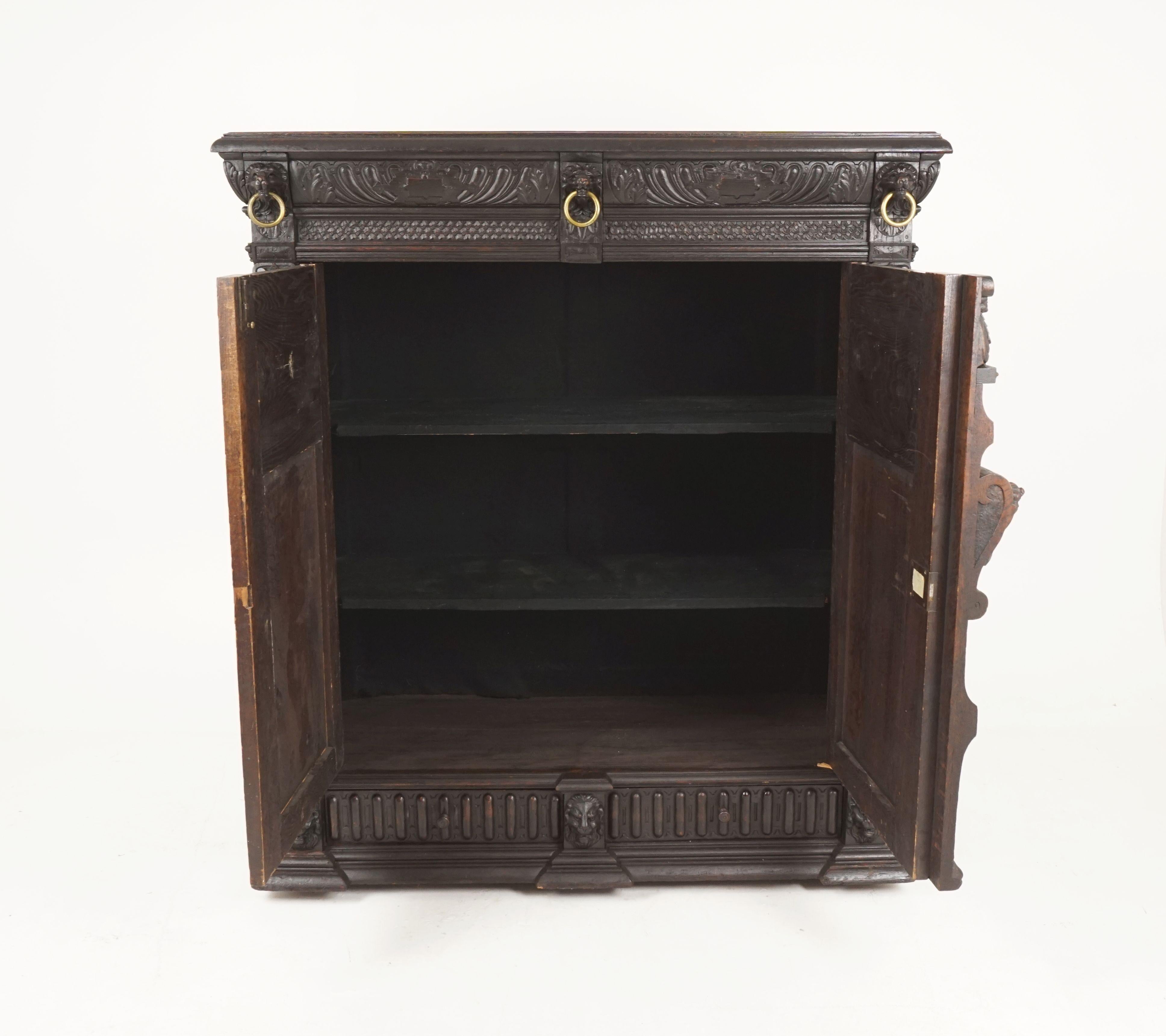 Antique French carved oak 19th century hall cabinet, side cabinet, France, 1880, H068

France, 1880
Solid oak
Original finish
Rectangular moulded top
Carved frieze
Three lion's heads with brass rings
Pair of heavily carved paneled doors
Opens to