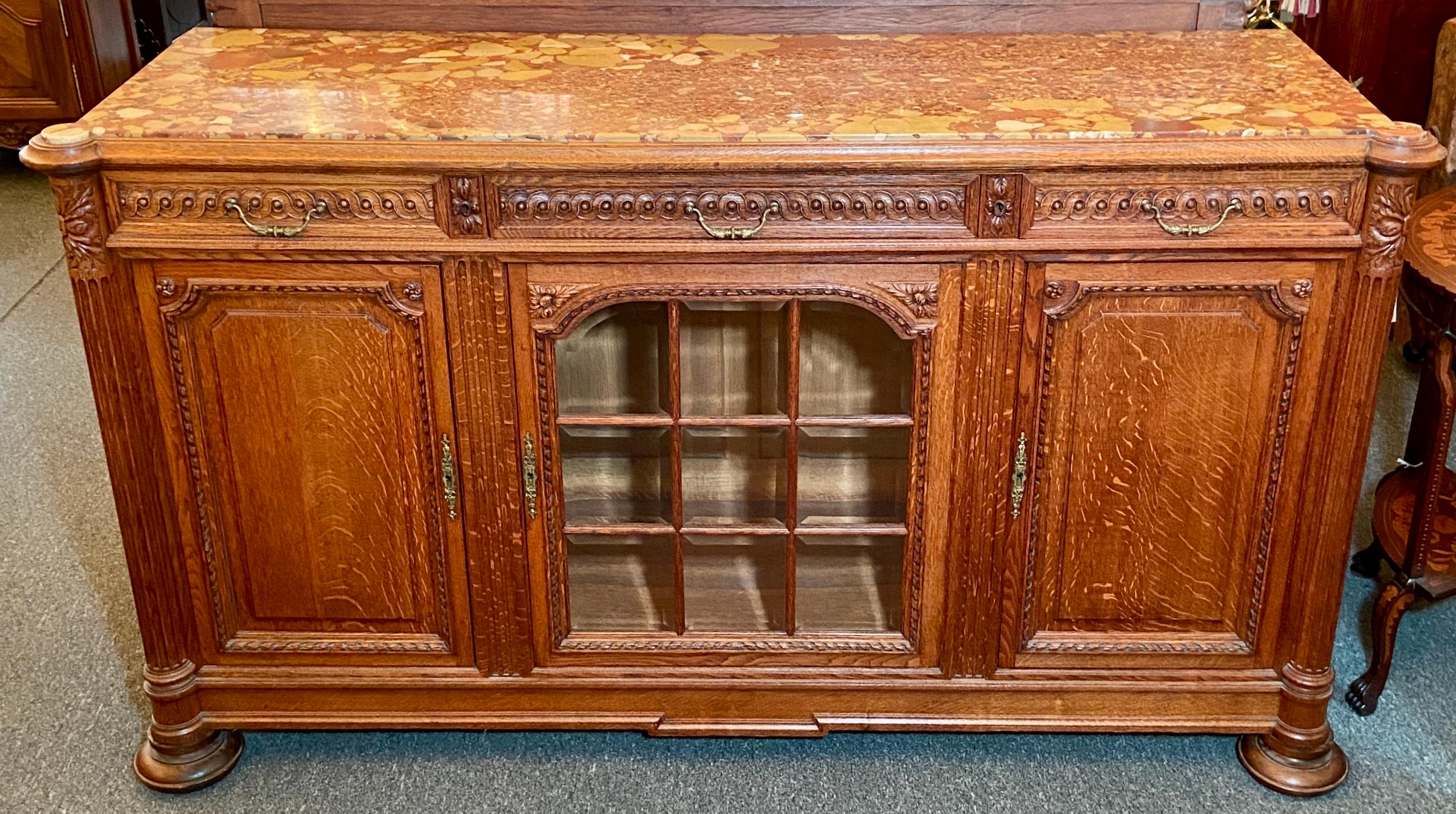 Antique French carved oak buffet with beveled glass door and original marble top, circa 1900.