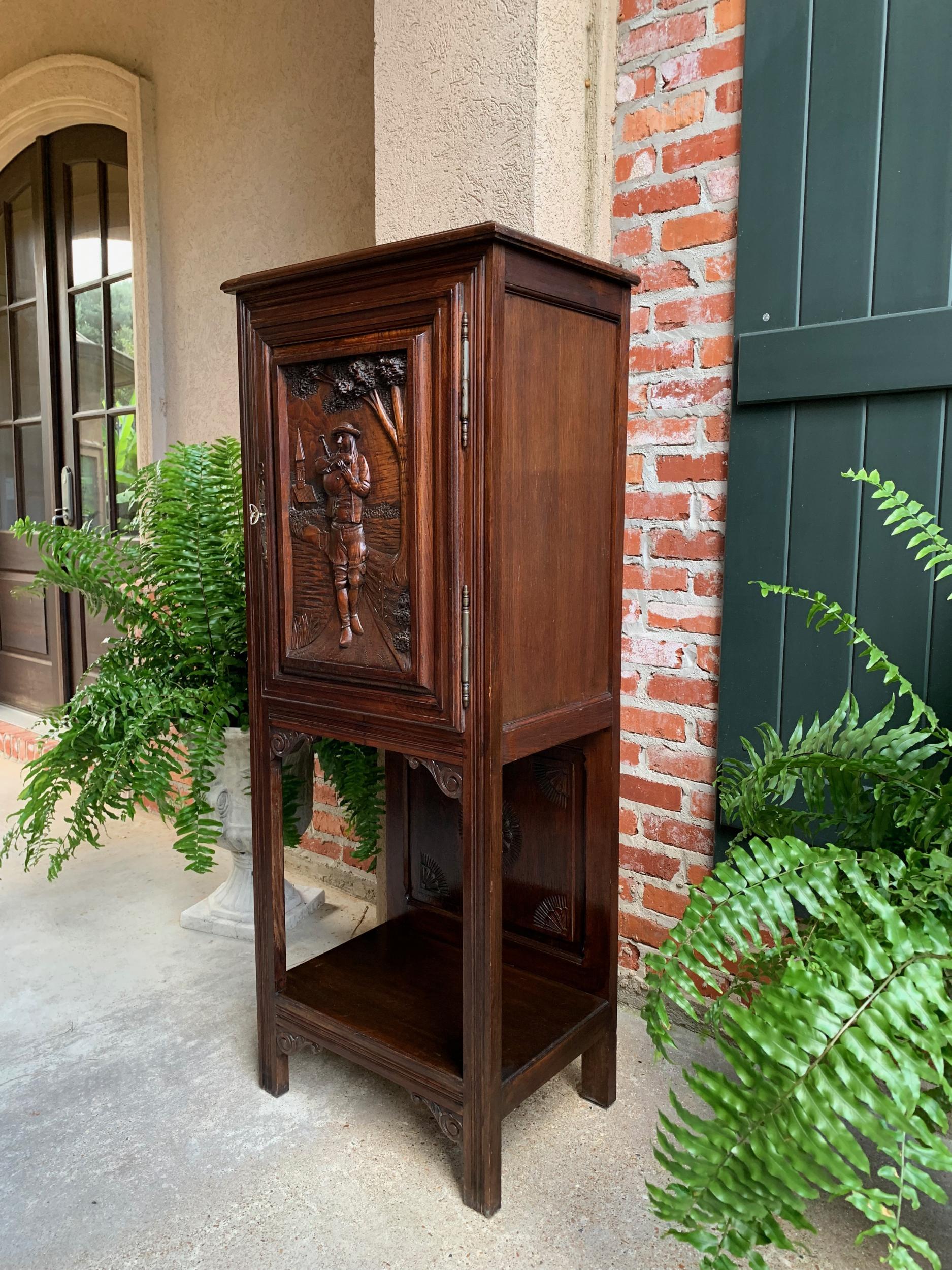 Antique French carved oak cabinet Breton bagpipe Brittany petite bookcase.

~Direct from France~
~Tall and slender antique French cabinet, with very unique Breton carvings!~
~The most outstanding feature is the large, dimensionally carved door panel