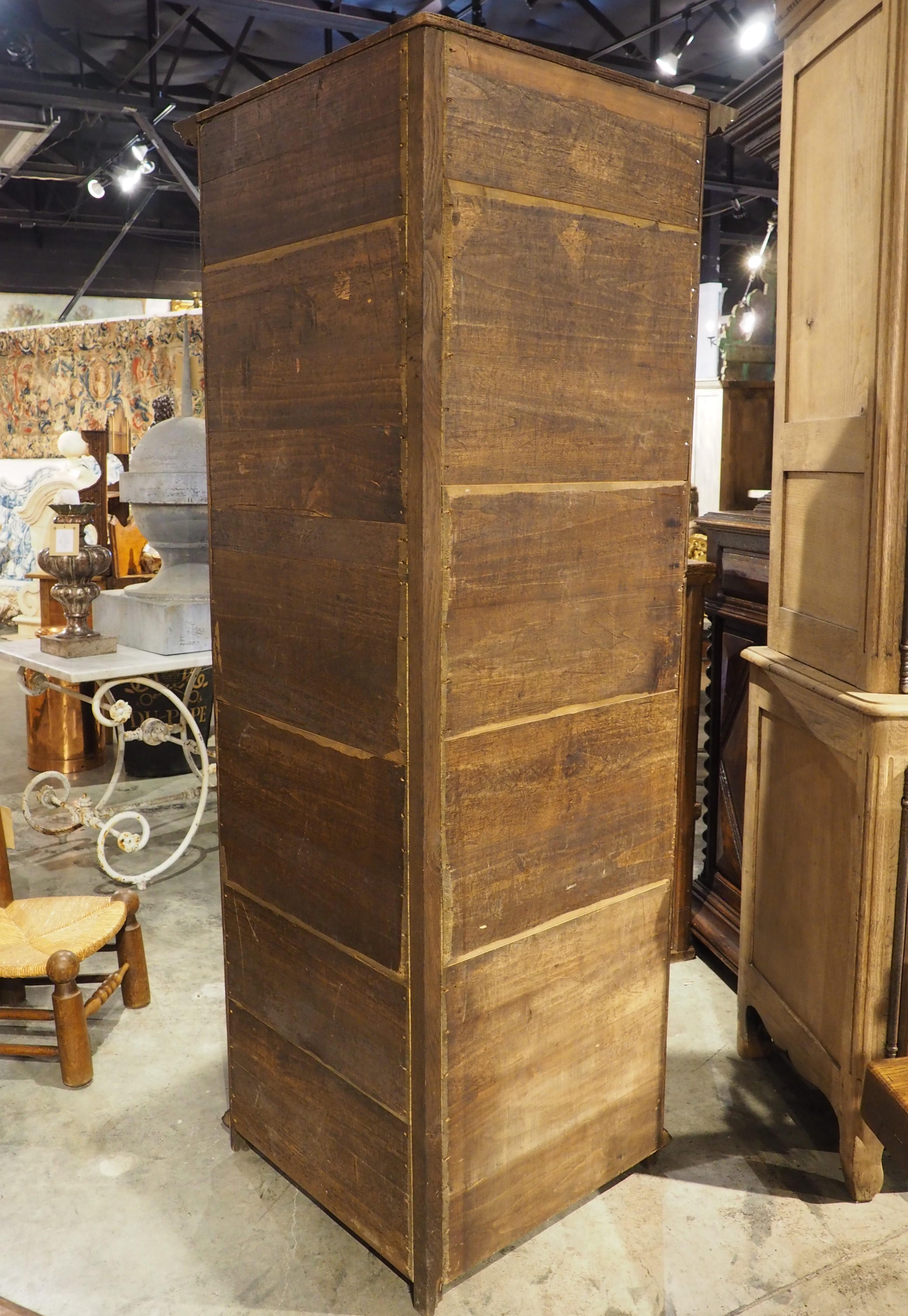 Designed to maximize efficiency without sacrificing floor space, this oak corner cabinet was hand-carved in France, circa 1885. The form is reminiscent of a bonnetiere, which is a single-door wardrobe (smaller than an armoire) that first appeared