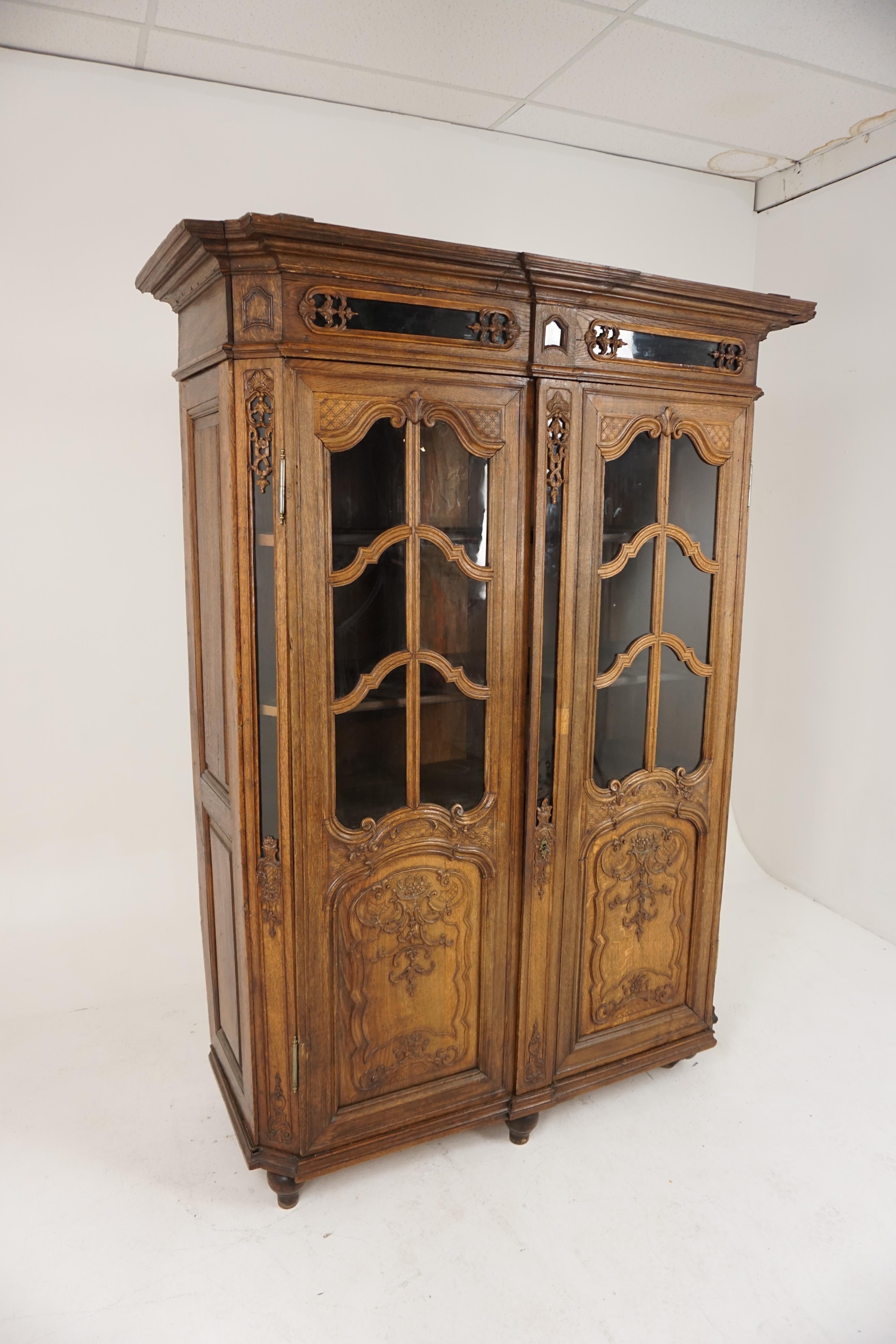 Antique French carved oak display cabinet, bookcase France 1890, B2037

Solid oak
Original finish
Carved break front cornice on top
Pair of small carved rectangular glass windows underneath
Pair of heavily carved original glass doors with